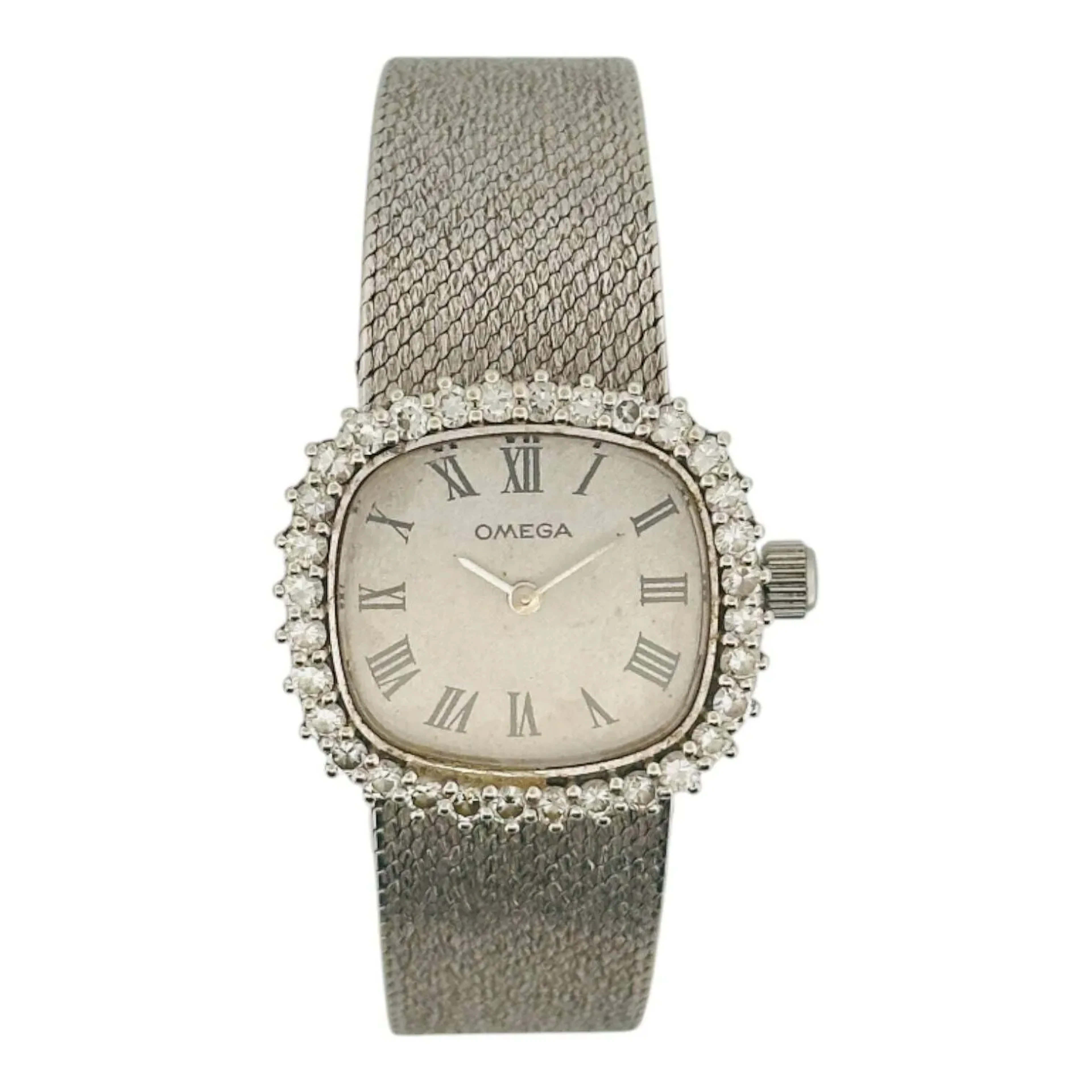 OMEGA Montre-bracelet de forme en or gris 18K (750 millièmes), cadran argenté, index chiffres romains en décalques noires, aiguilles fils argentées. Lunette sertie de diamants taille brillant. Fond clipé en or gris 18K (750 millièmes), à l’intérieur signature JMPL. Mouvement mécanique à remontage manuel signé Omega calibre 620. Bracelet en or gris 18K (750 millièmes) fermeture à échelle. Montre fonctionnelle lors de l’expertise, sans garantie de fonctionnement futur et d’état des pièces. Rayures au boitier et au bracelet, marques au cadran, tige et couronne modifiées. Vers 1969 Poids brut 51 g Dimensions 25 x 25 mm