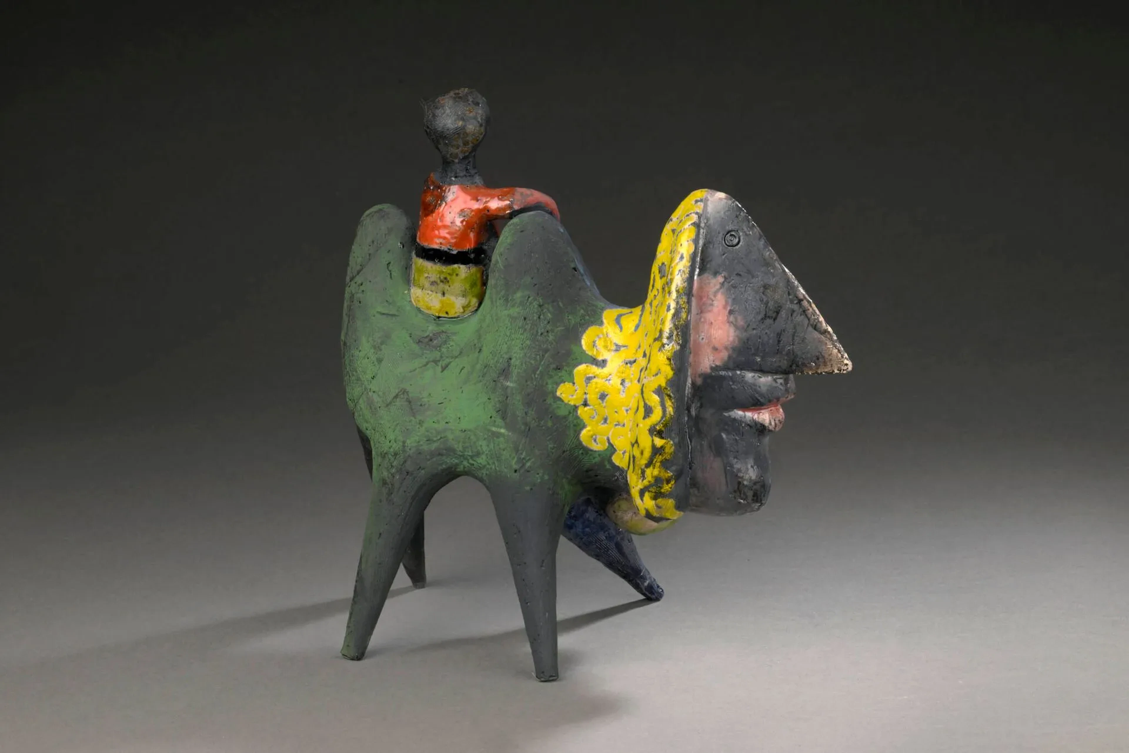 Roger CAPRON (1922-2006) Sculpture, circa 1996, figurant un chameau stylisé et son cavalier Épreuve en faïence émaillée enfumée polychrome Signé R. Capron H. : 25.5 cm. - L. : 26.5 cm. - P. 13 cm. (Usures) Bibliographie : - Pierre Staundenmeyer, Roger Capron Céramiste, Edition Norma, 2023, sculpture à rapprocher reproduit p. 164.