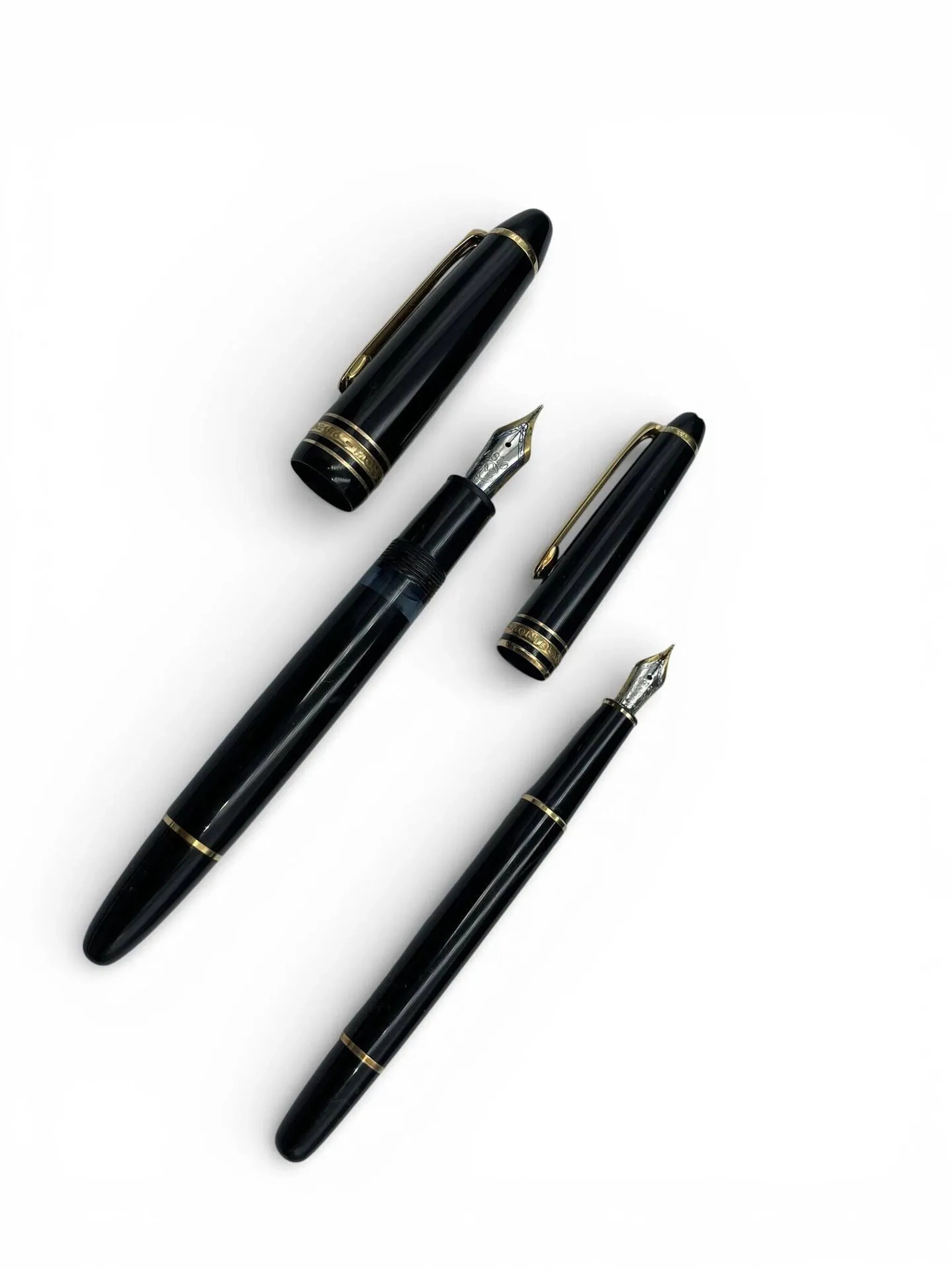 MONTBLANC Deux stylos plume Meisterstück en résine noire, l'un N°146, plumes en or jaune et gris (750). Signés et numérotés Petites usures Etui en cuir noir de la maison.
