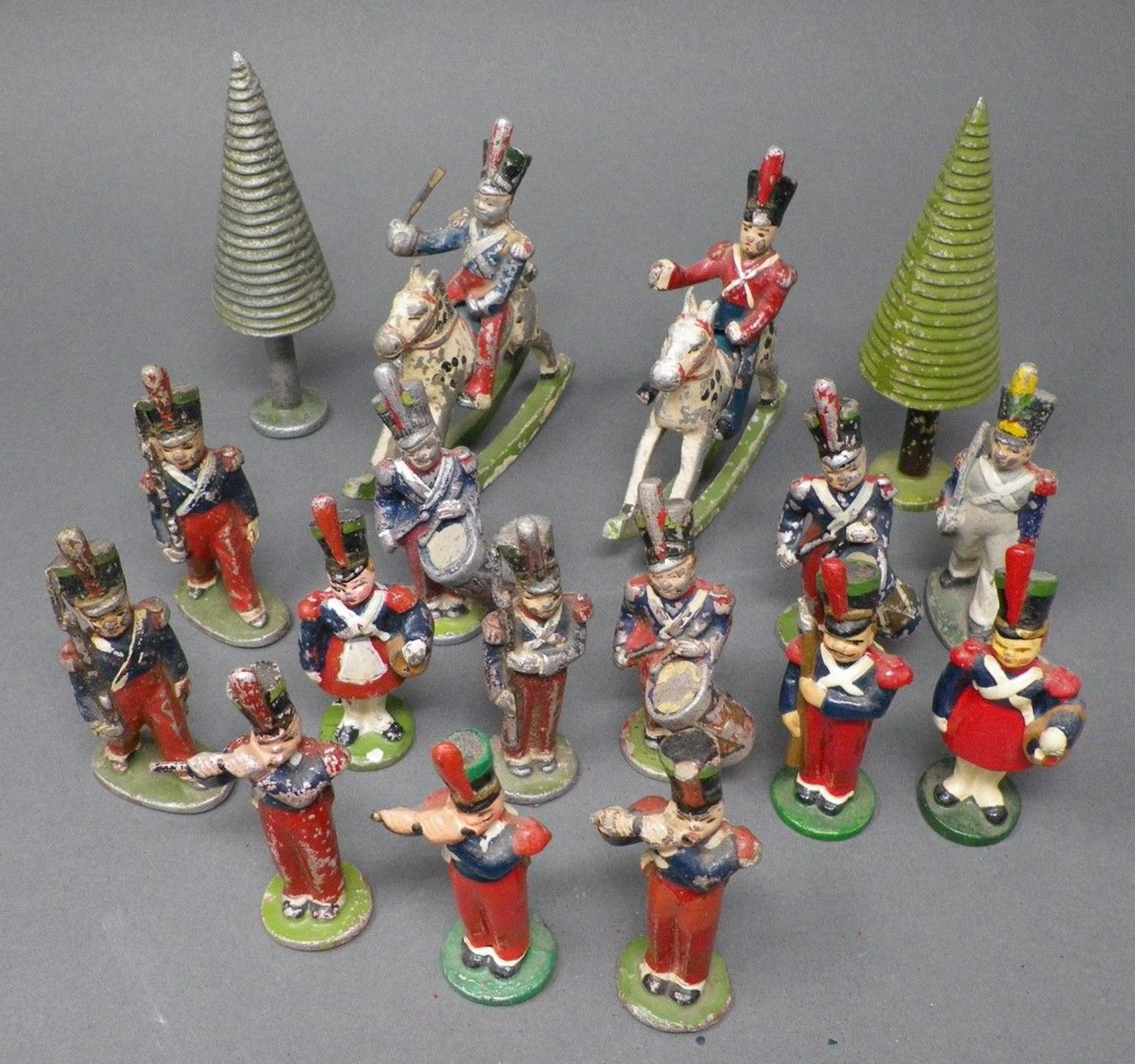 QUIRALU - Fanfans Quinze figurines et deux arbres, dont : officiers à cheval, cantinières, tambours, reproduits p. 146 - Bibliographie : Les jouets Quiralu 1933-1964 - R. Alazet - J. Borsarello - H. Giroud - Ed° J. Granchet Paris. Jouets anciens pouvant présenter des manques de peinture, des chocs ou des manques, y compris pour les conditionnements éventuels. Vendus en l'état et sans réclamations.