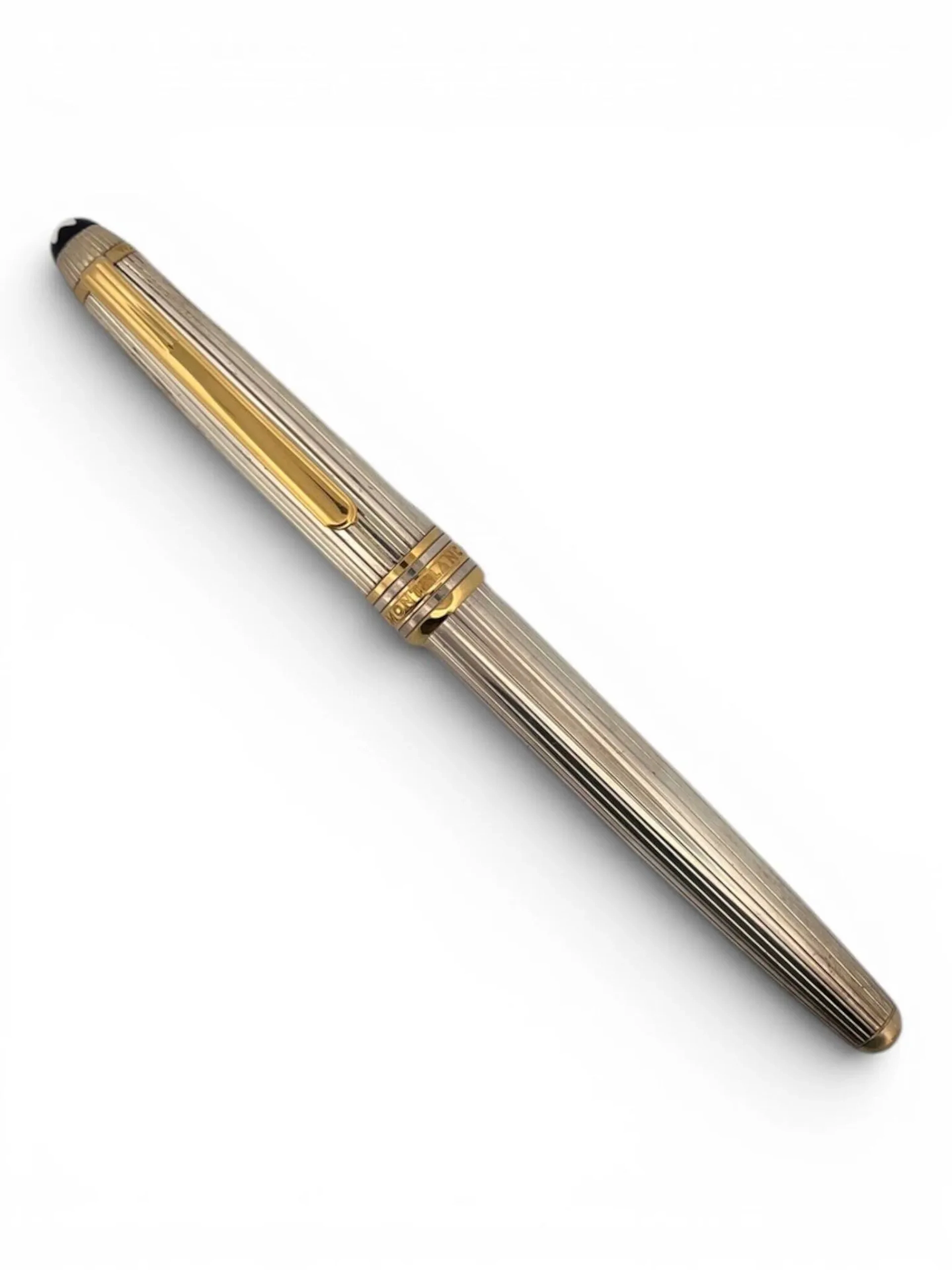 MONTBLANC Stylo plume MEISTERSTÜCK en argent (925) cannelé. L'agrafe et les anneaux en métal doré, plume en or (750). Bague numérotée "VV1004171" Poids brut: 30,5 gr ; Long. 13,2 cm Dans son écrin, sa boîte et sa surboîte
