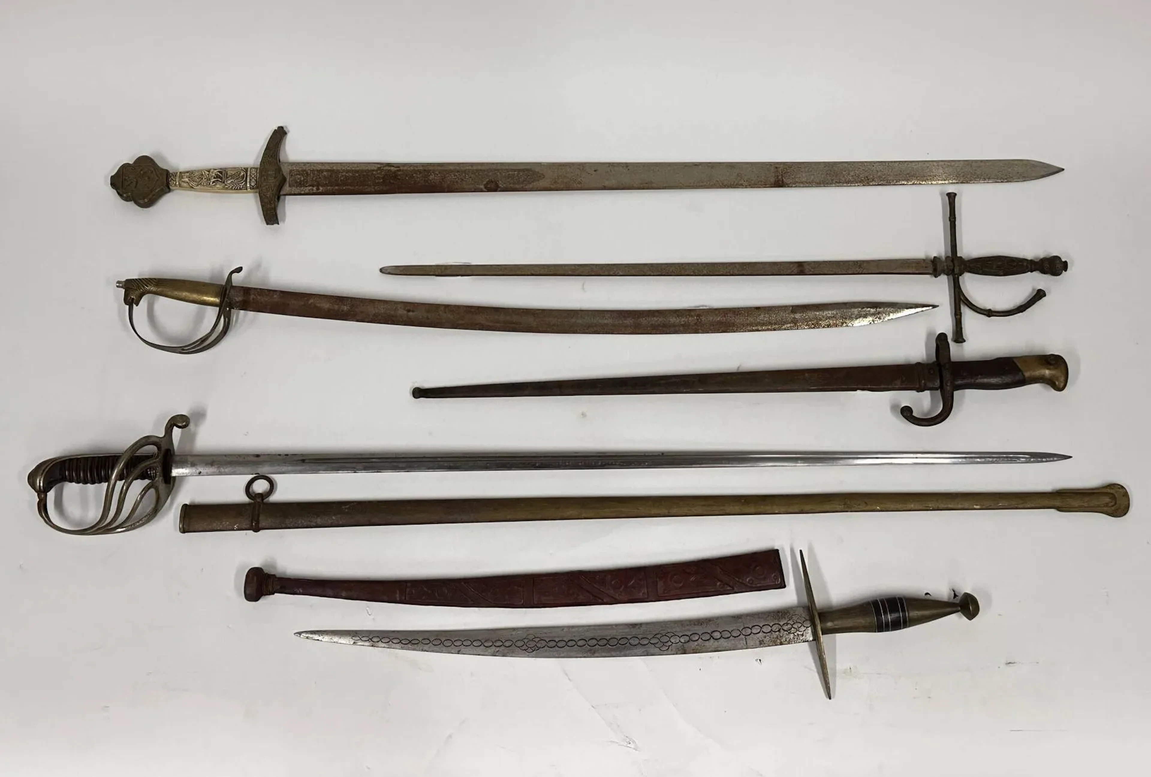 Ensemble de six pièces. Comprenant : -Sabre d’officier d’infanterie modèle 1882 (Châtellerault, Juin 1914). -Baïonnette 1874, Gras. -Deux épées de style. -Souvenir type touareg. -Copie de sabre indien.
