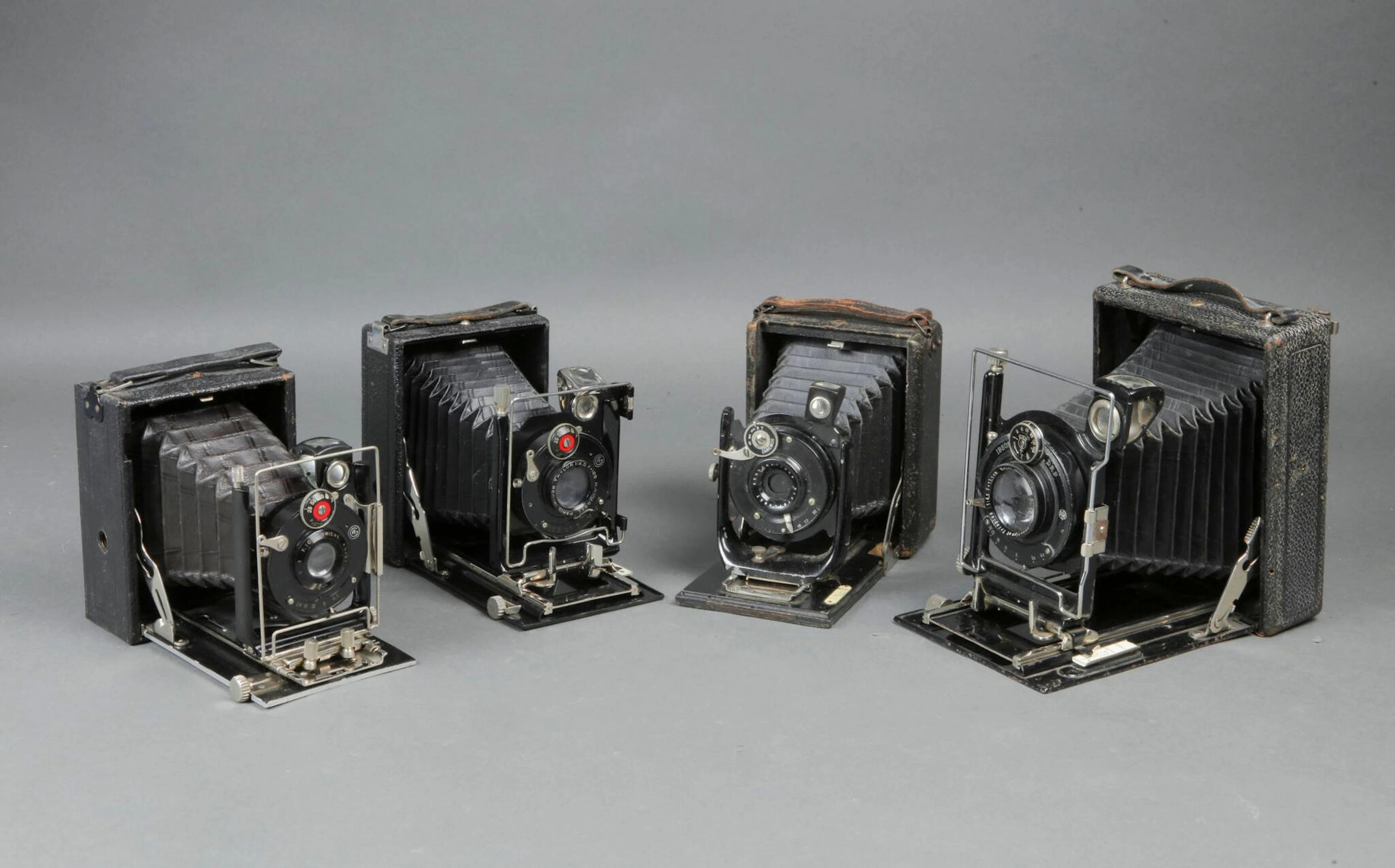 Set of four small camera bodies with various plates, as-is. - Lot 422