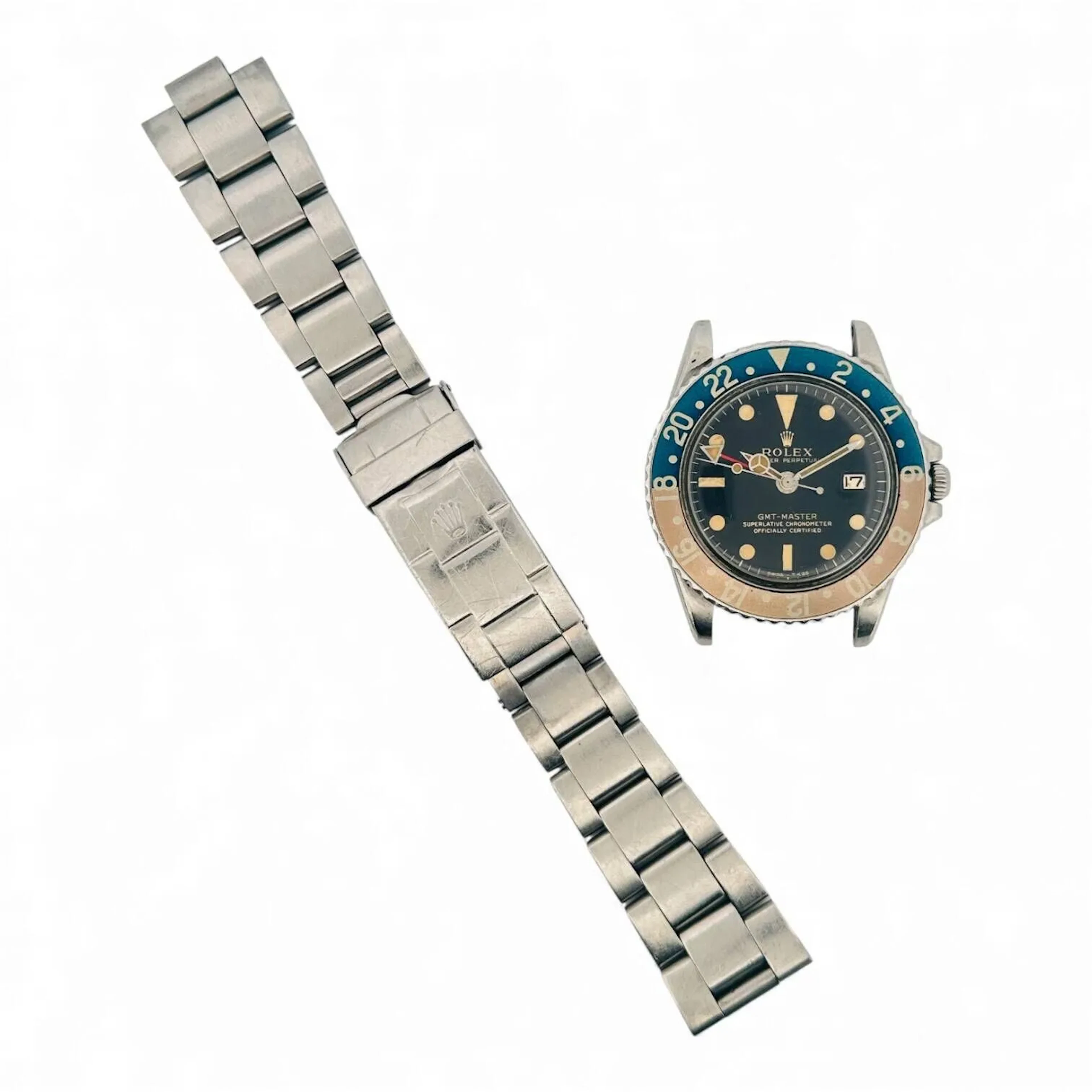 ROLEX GMT-MASTER RÉF. 1675 Montre-bracelet en acier, cadran noir brillant « gilt », index peints avec matière luminescente tritium, aiguilles « Mercedes », aiguille centrale de GMT, date à trois heures. Lunette tournante en acier, insert de lunette en aluminium bleu et rouge avec repères 24 heures. Fond de boitier vissé en acier à l’intérieur signé Rolex, référence 1675 et gravure calendaire II.71. Boitier référence 1675 et numéroté 3034133 entre les cornes. Mouvement mécanique à remontage automatique Rolex calibre 1560. Bracelet de type Oyster en acier référence 93150, code A. Montre fonctionnelle lors de l’expertise, sans garantie de fonctionnement futur et d’état des pièces. Rayures, léger accident au centre du cadran sur la peinture,quelques défauts aux points tritium, boitier poli de nombreuses fois, bracelet Rolex non original à la montre, manque les pièces de bout. Vers 1972 Diamètre 40 mm