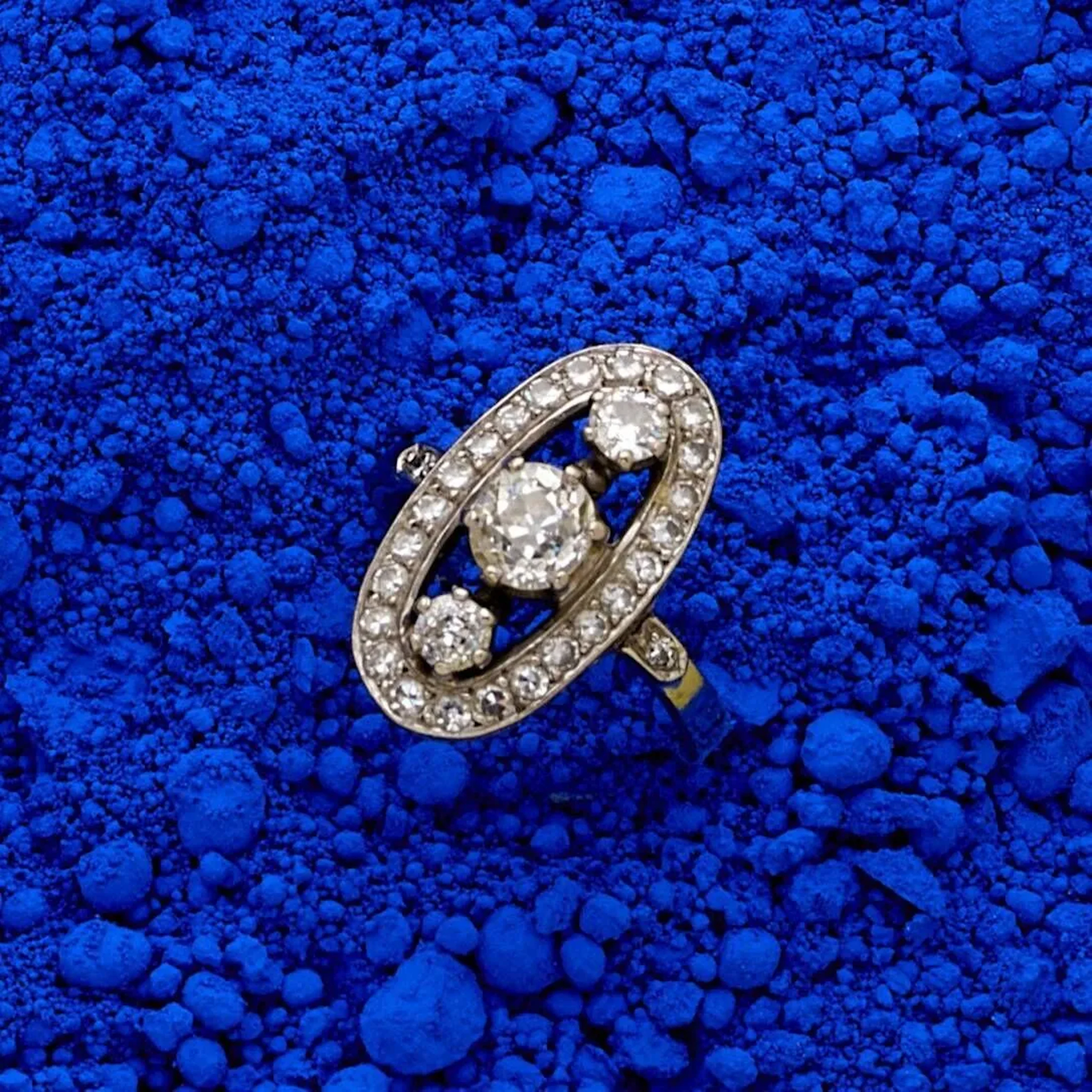 Bague marquise en or gris 18k (750e), centrée de 3 diamants taille ancienne dont un plus important au centre pesant 0.50 ct environ, dans un entourage de diamants taille 8/8. Poids brut : 5.50 g. Tour de doigt : 52.