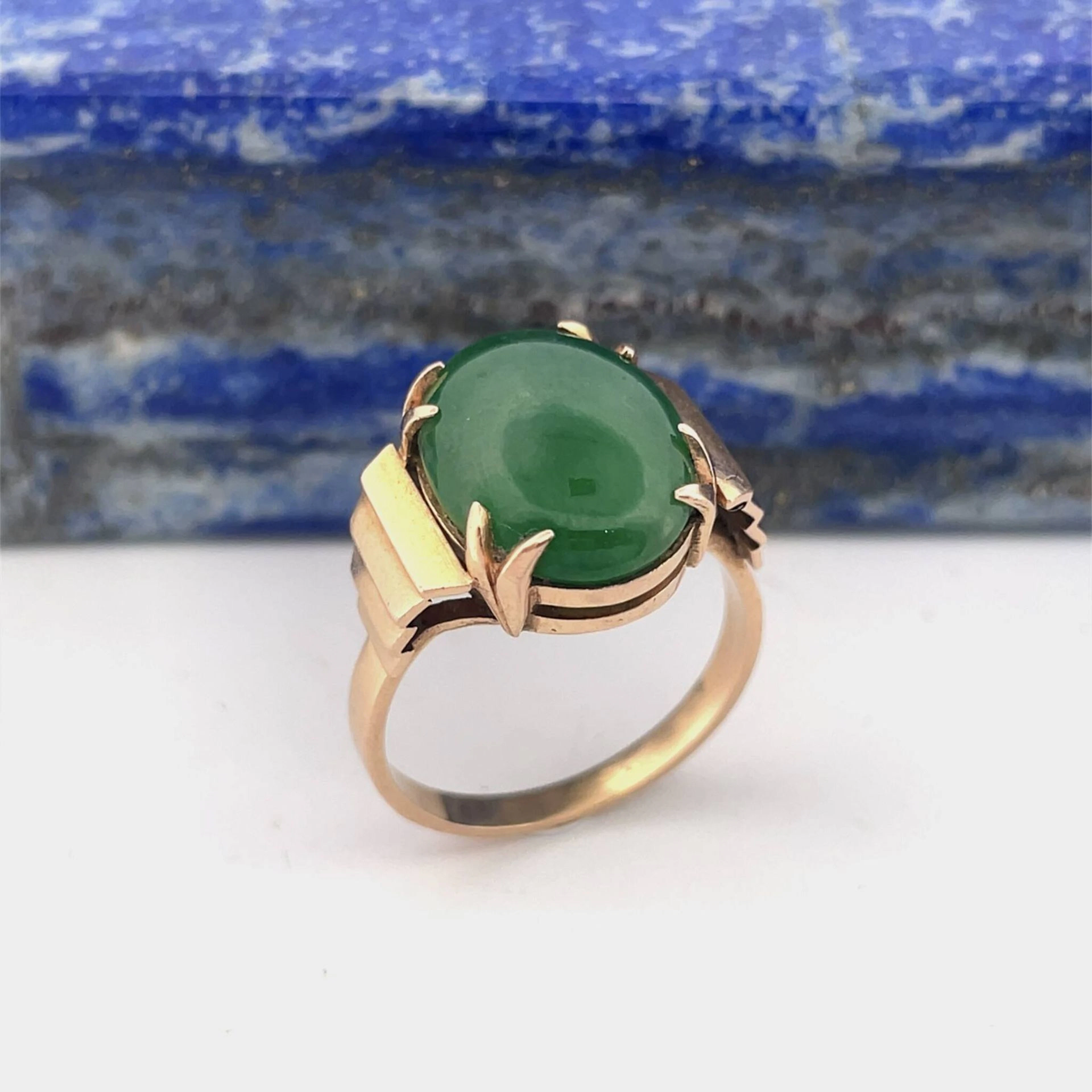 Rose gold (750) ring set with an oval cabochon jade, flanked - Lot 253