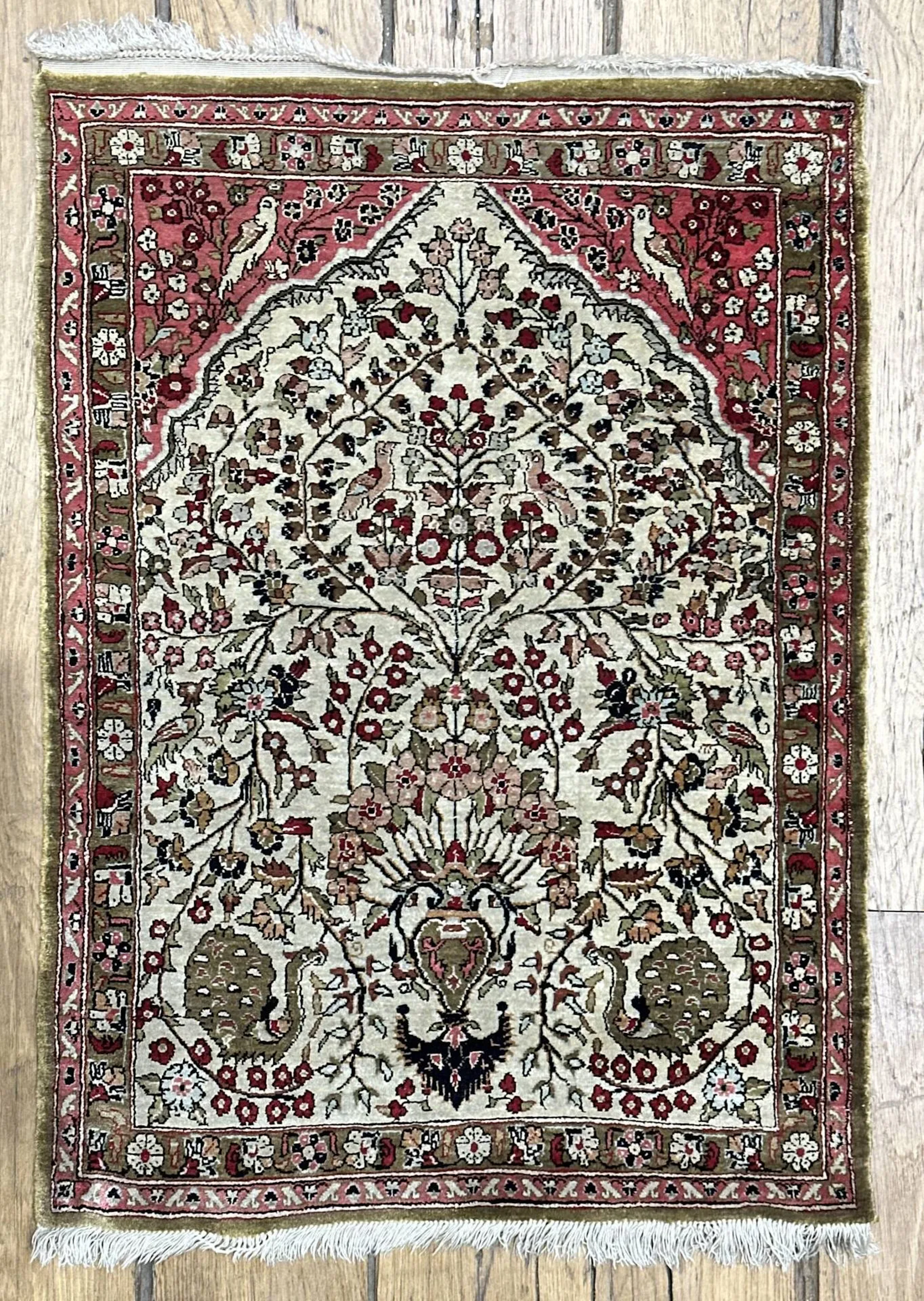 Fin Ghoum en soie Iran Époque du Shah Vers 1965 Dimensions 080 x 057 cm Velours de soie sur fondations en soie 100% en soie Densité env 9/10000 nœuds au dm² Belle finesse Bon état général Tapis de forme prière Champ ivoire à décor d'un mirhab stylisé , vase richement fleuri orné de volatiles stylisés Bordure principale vieil or