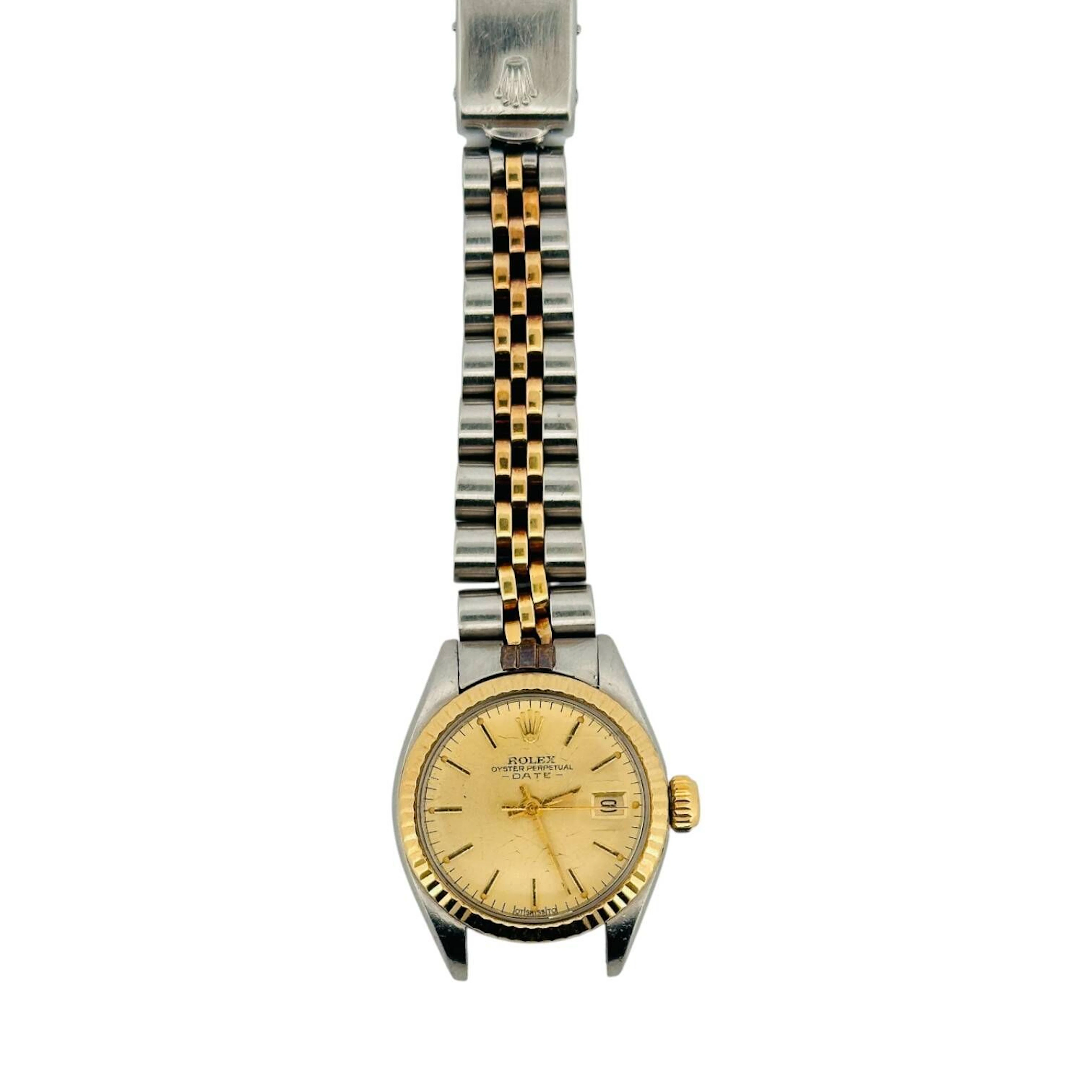 ROLEX OYSTER PERPETUAL DATELADY Montre bracelet de dame en or 18K (750 millièmes) et acier, cadran doré soleillé, index en applique dorées avec insert noir, point tritium, aiguilles bâtons dorées, date à trois heures. Lunette cannelée en alliage d’or. Boitier référence 6917, numéro de série 4078305. Couronne signée Rolex. Fond de boitier vissé en acier, à l’intérieur signé ROLEX, référence 6917. Mouvement mécanique à remontage automatique Rolex calibre 2030. Bracelet en or 18K (750 millièmes) et acier type Jubilé, boucle déployante signée Rolex référence 62523D 14, code A. Montre fonctionnelle lors de l’expertise, sans garantie de fonctionnement futur et d’état des pièces. Rayures et légères marques au boitier et au bracelet, faiblesses multiples au bracelet, accidents au verre. Vers 1976 Diamètre 25 mm