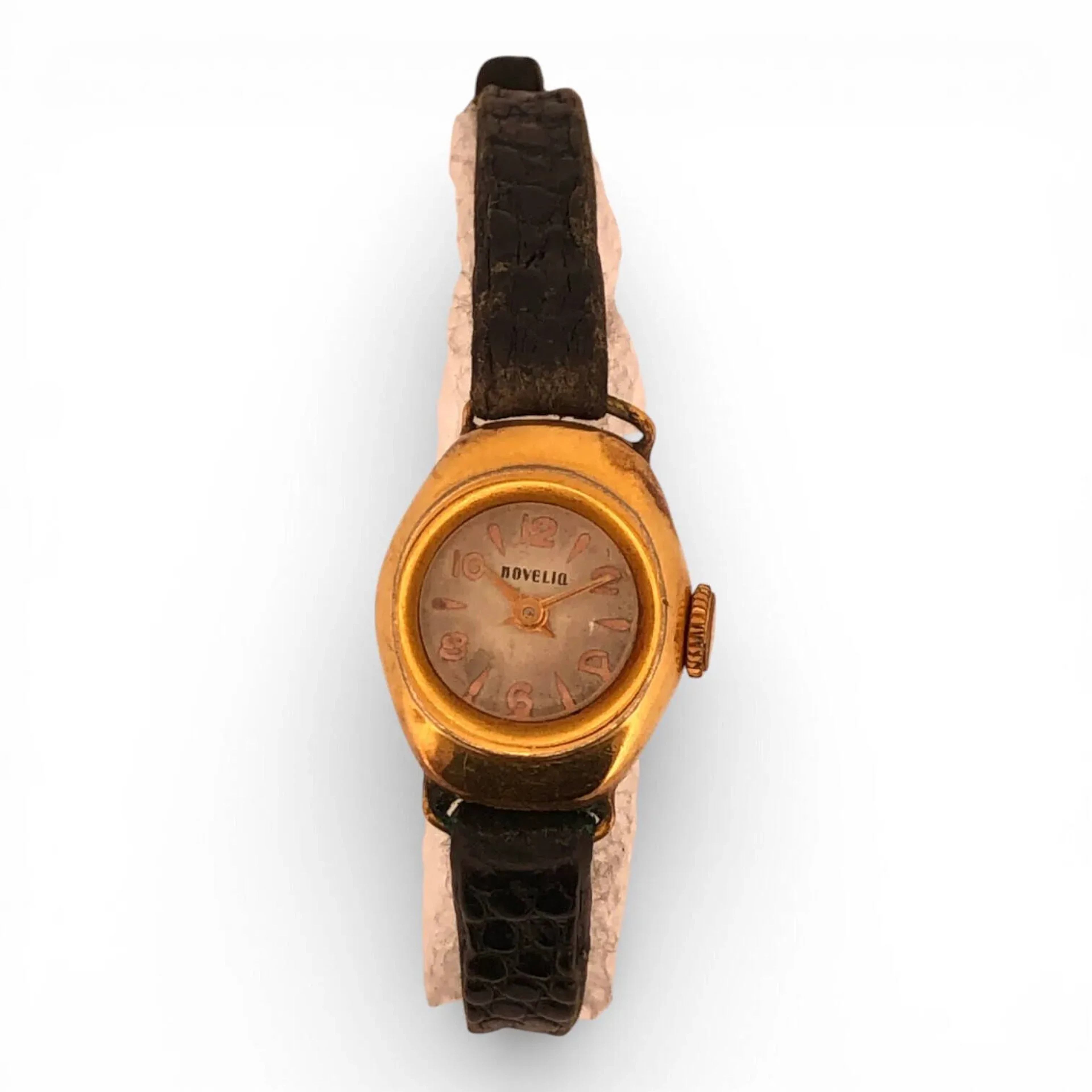 NOVELIO Montre bracelet de dame, le boîtier arrondi en or jaune (750), cadran signé à chiffres arabes pour les heures, fond en acier, bracelet en cuir noir (fortes usures) Poids brut: 11,4 gr Petits chocs et rayures