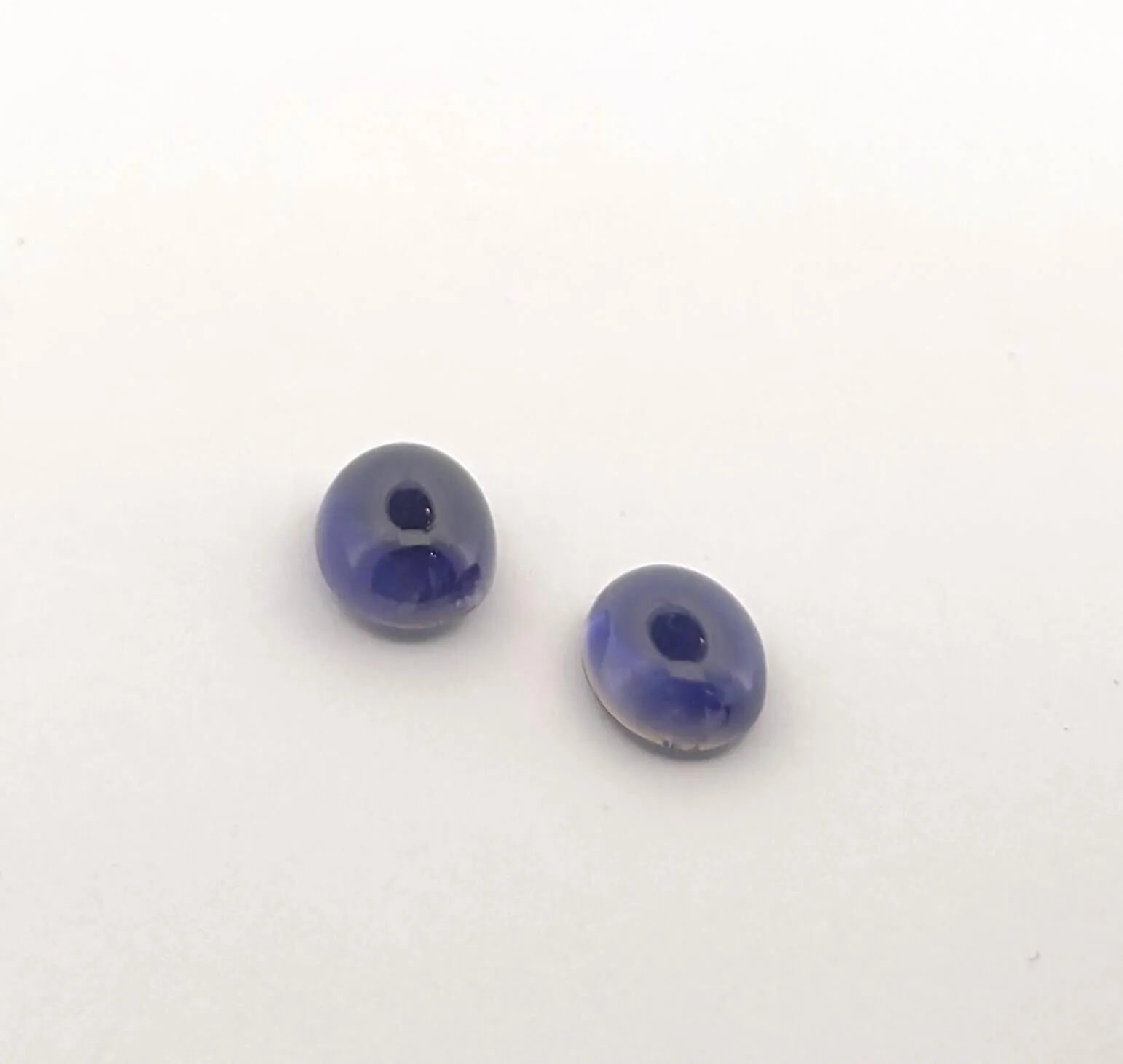 Pairing of two iolite cabochons on paper. Size: 10 x 8 mm. W - Lot 58