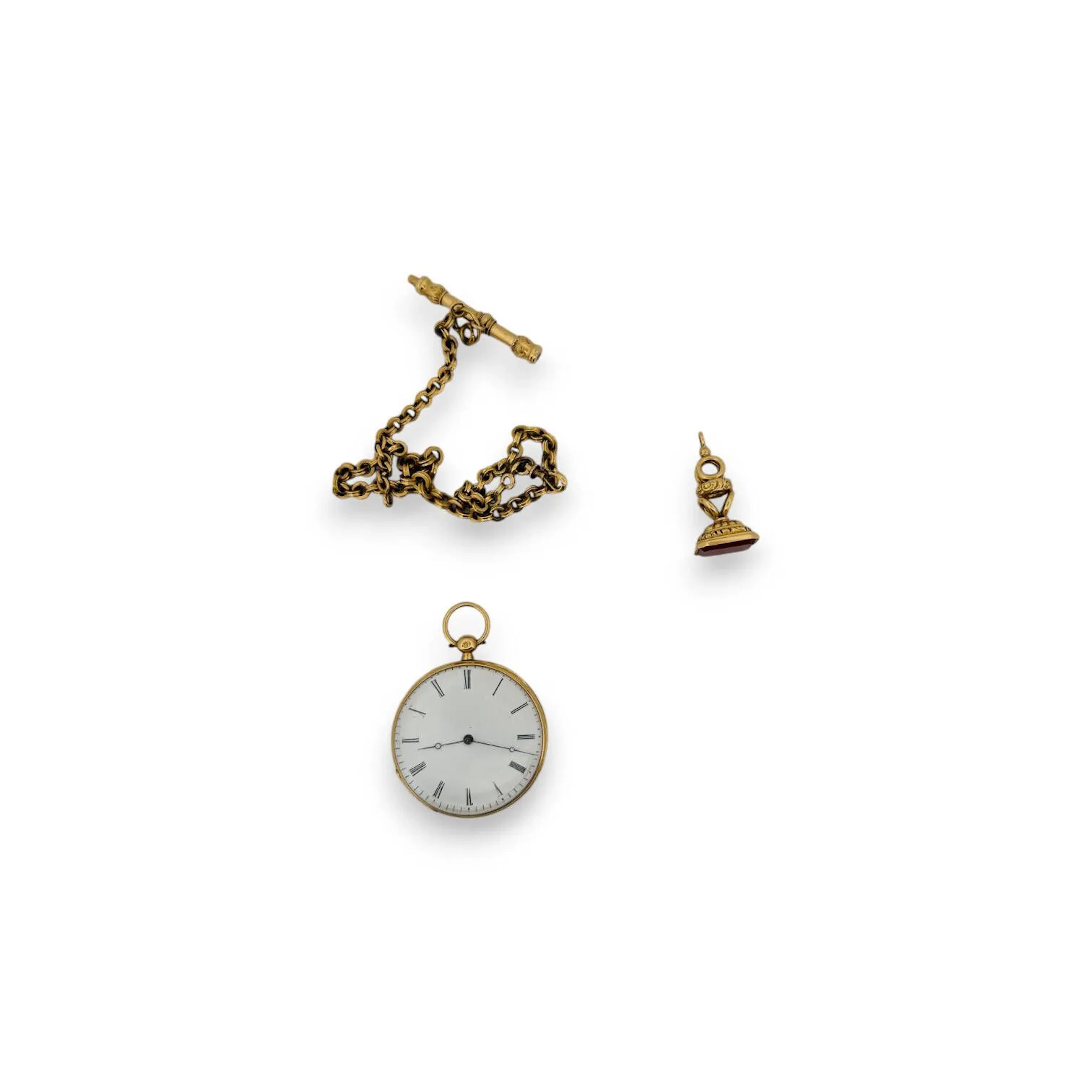 ANONYME N°38381 Montre de gousset en or jaune 18K (750), cadran émaillé blanc, index chiffres romains formant les heures, mouvement à clef, boitier cannelé, cuvette arrière à décor ciselé de fleurs et feuillages, cache-poussière en or 18K. Poinçon chimère (1838-1893) et tête d'aigle. Diam. : 40 mm - Poids brut : 41.73 g. On y joint une chaine en or 18K se terminant par une clef et retenant un cachet en or 18K serti d'une cornaline à pans coupés. Poids brut total : 19.60 g.