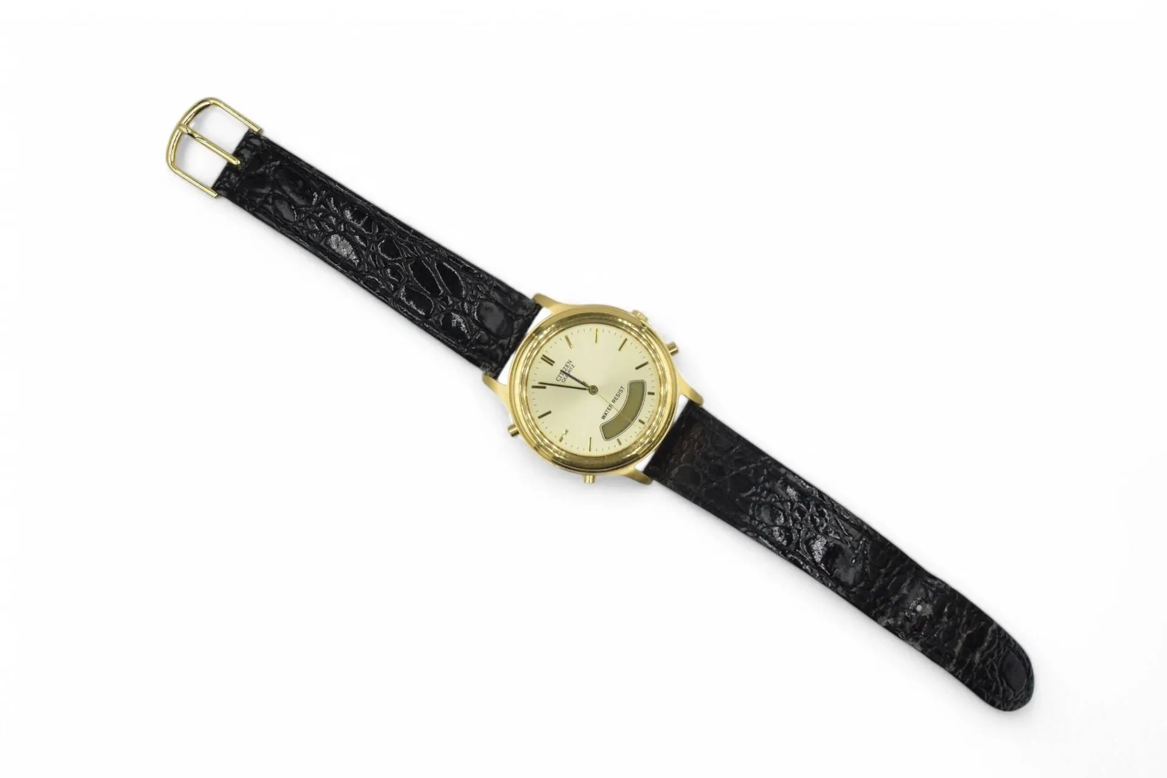 CITIZEN Montre bracelet d'homme en métal doré, index bâtons dorés sur un fond crème, guichet d'affichage à 6h. Bracelet en cuir noir (état d'usage), boucle à ardilllon. Pile à changer.