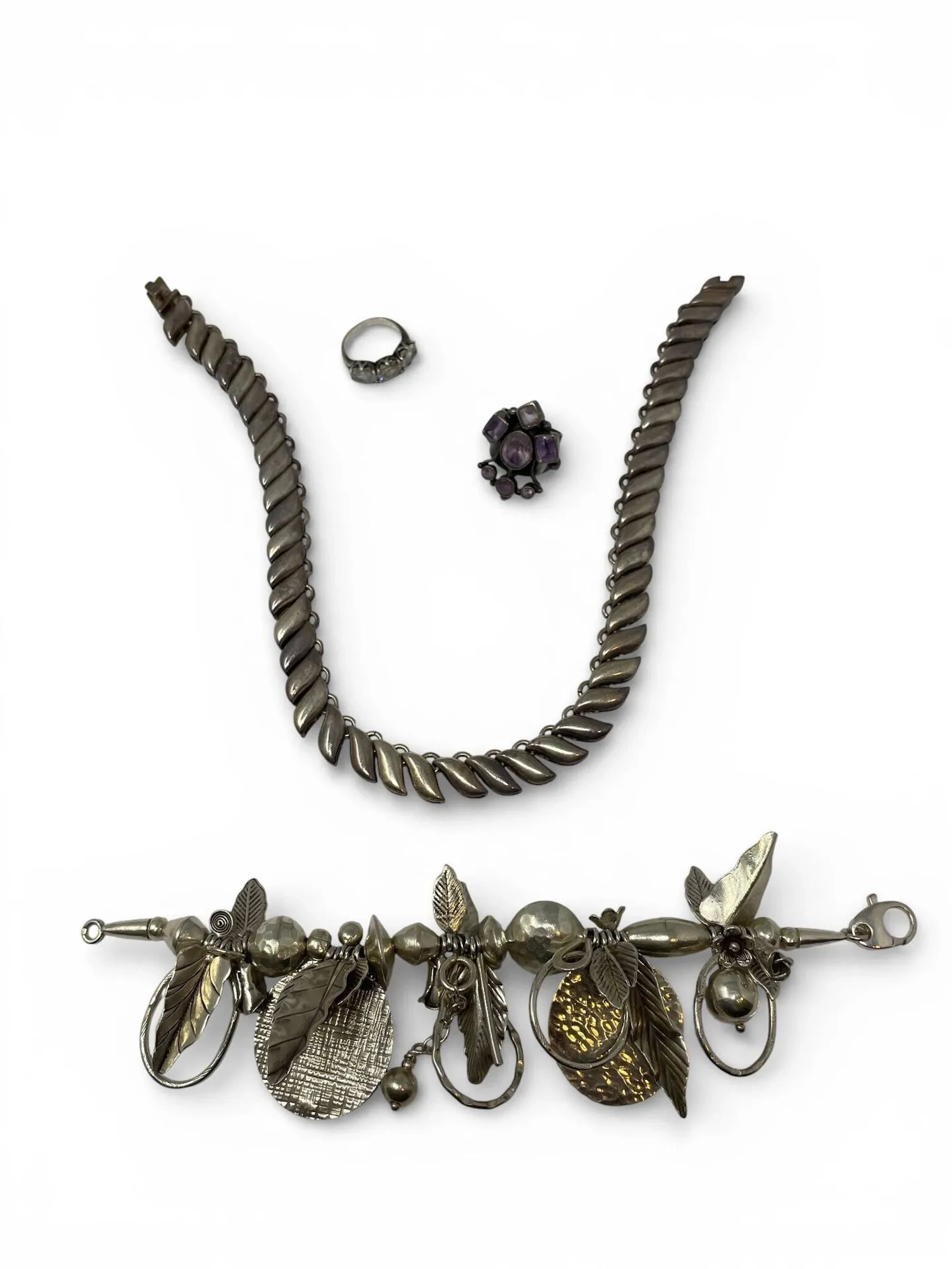 Lot de bijoux en argent : Un bracelet en argent à perles formant des végétaux PB 73,2 g Une bague en argent sertie de trois pierres blanches taille ovale Pb : 3.8g Une bague en Argent sertie de sept améthystes ? PB 10,7g Collier en argent maillons végétaux, Mexique. PB 91,3g