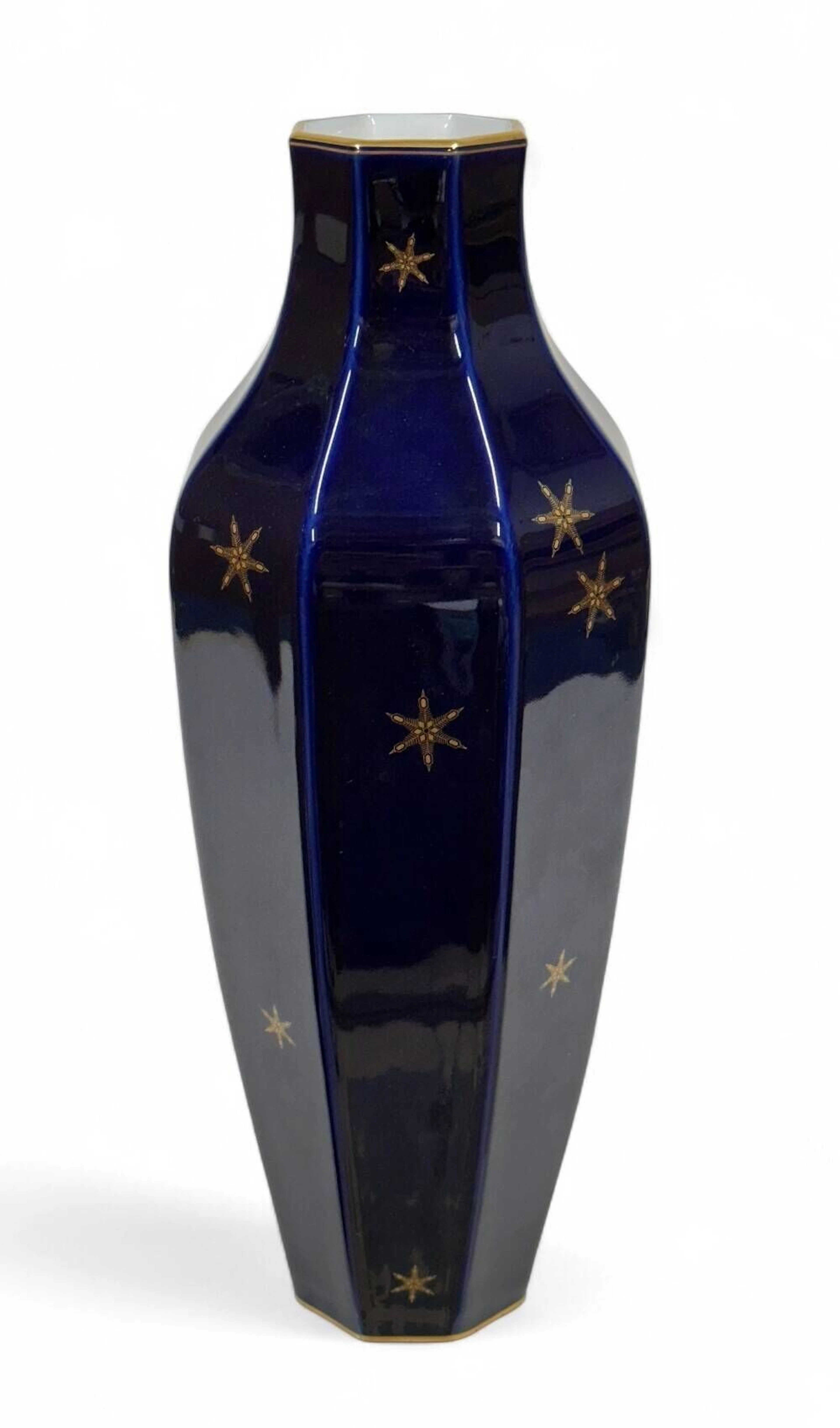 SÈVRES Vase “d’Alençon à pans” en porcelaine, à pâte dure ancienne, à fond beau bleu et décor en or d’un semis de flocons de neige, filet or sur les bords. Manufacture nationale de Sèvres, 1922. Marque au tampon vert de fabrication “S. 1922. DA” au revers. H. 41 cm.