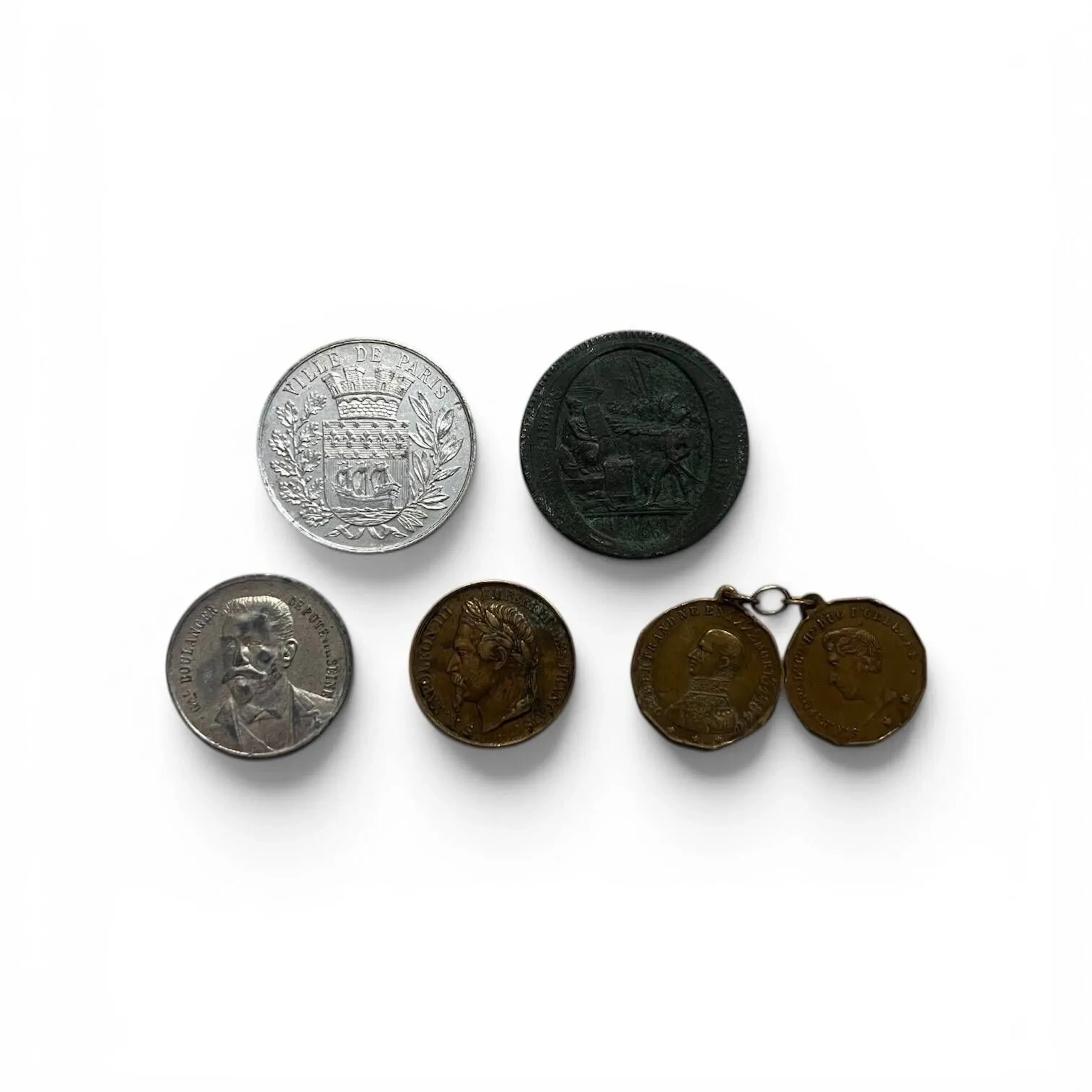 Ensemble de médailles et jetons divers XIXème siècle : - Médaille en cuivre pour l'élection de Napoléon III Avers : tête laurée de l'Empereur de profil gauche. S.M. Napoléon III empereur des français. Graveur : Joseph Dantzell Revers : élu par 7824189 suffrages le 2 décembre 1852 Diam. : 28 mm - Jeton en alliage, prime du " Journal du Peuple " pour l'élection législative, avec portrait du général Boulanger, 27 janvier 1889. Diam. : 30 mm - Usure - Jeton publicitaire en aluminium. Avers : comptoir des spécialités brevetées Aluminium pur de l'usine de Froges Isère. Revers : armes de la ville de Paris. Diam. : 36 mm - Deux médailles en laiton réunies par trois maillons de chaîne : Avers : ***G.LE BERTRAND NE EN 1772 MORT LE 31 JER 1844. Buste en tenue militaire de profil à gauche. Revers : IL ATTENDAIT SON FIDELE AMI. Tête de profil à droite de Napoléon. Avers : S.A.R. F_ND P_IE L_IS C_LES H_RI DUC D'ORLEANS. Portrait de Ferdinand Philippe duc d'Orléans (fils aîné de Louis-Philippe, décédé dans un accident, le 13 juillet 1842, durant le règne de son père). Revers : la Chapelle où repose le Prince. Inscription : CHAPELLE FERDINAND - Monneron en cuivre de 5 sols au serment An IV 1792. Avers : Dans un cartouche ovale, scène du serment La fête de la Fédération avec Pacte fédératif. Signé Dupré F. VIVRE OU MOURIR, à l'exergue 14 juillet 1790. Revers : Au centre, Médaille de confiance de cinq-sols remboursable en assignats de 50. L'An IV de la liberté MONNERON FRERES NEGOCIANS A PARIS. Forte oxydation.