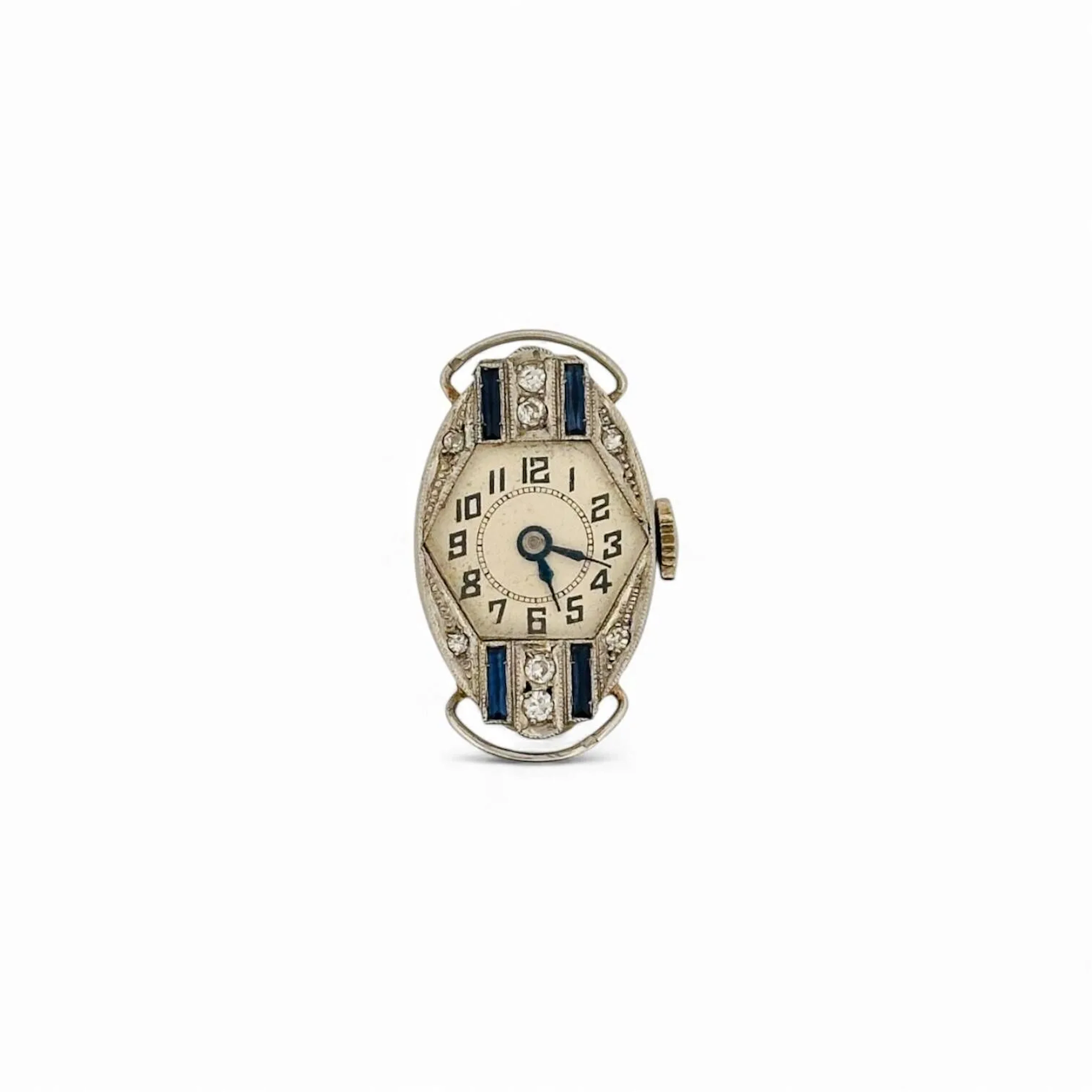 Boîtier de montre en or jaune (750) et platine (950), cadran à chiffres arabes pour les heures et aiguilles en acier bleui, le boîtier sert de diamants et saphirs taille baguette. Epoque Art Déco Titre: poinçon hibou et mascaron Poids brut: 6,7 gr Usures