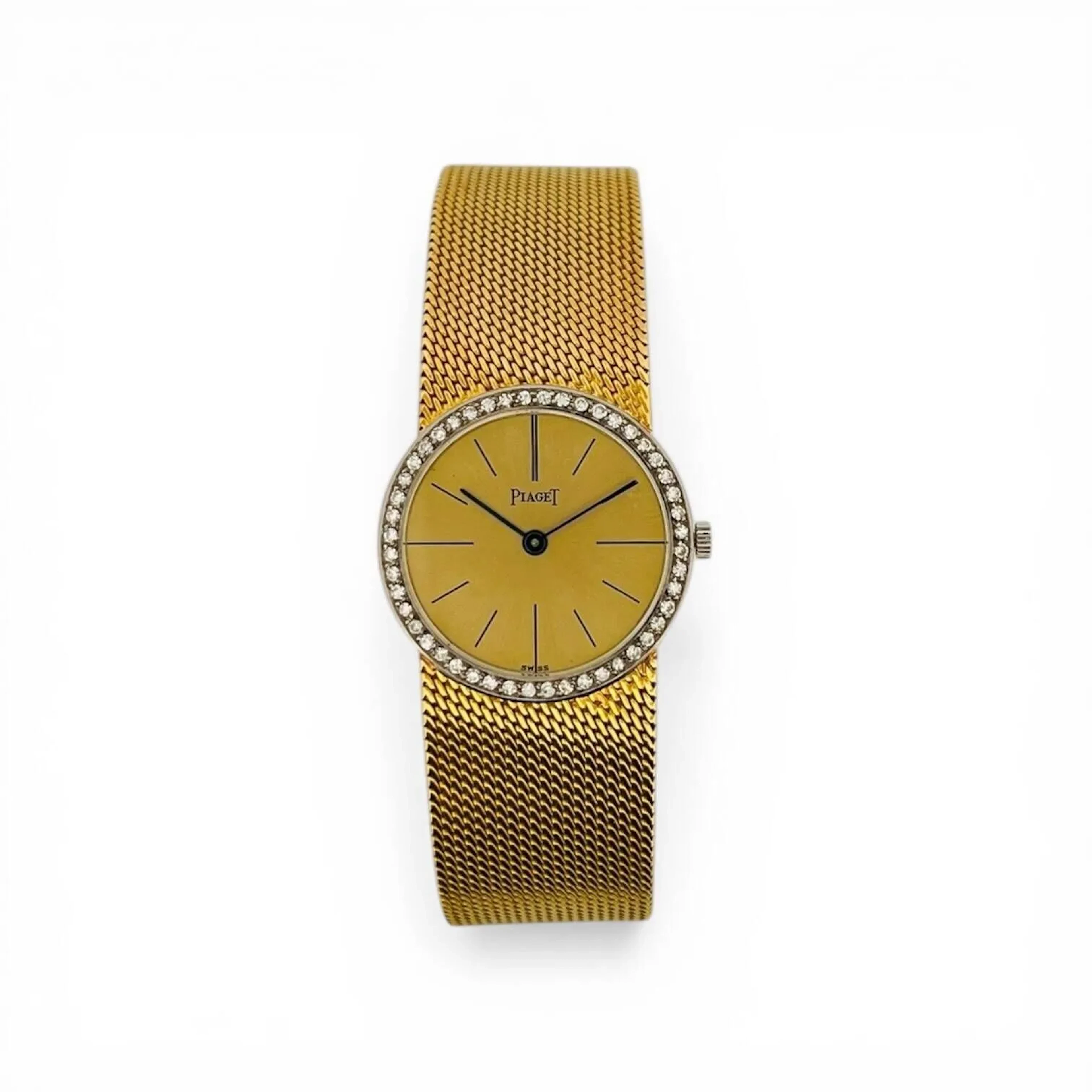 PIAGET Montre bracelet en or 18K (750 millièmes), cadran doré soleillé, index des heures en décalques noires fines, aiguilles fils bleuies. Lunette en or gris 18K (750 millièmes) sertie de diamants taille brillant. Fond à deux vis en or 18K (750 millièmes), référence 925B11, numéro de série 90706, poinçon d’importation George Lohac, à l’intérieur signé Piaget, fabrication Uli Rotach (clé de Genève 15). Mouvement mécanique à remontage manuel signé Piaget, calibre 9P, numéroté 634186. Bracelet en or 18K (750 millièmes), fermeture à échelle signé Piaget. Montre fonctionnelle lors de l’expertise, sans garantie de fonctionnement futur et d’état des pièces. Légères rayures légères au boitier et au bracelet. Accompagnée d’un écrin Hermès. Travail suisse vers 1970 Poids brut 48,1 g Diamètre 24 mm, pour un poignet d’environ 17,5 cm