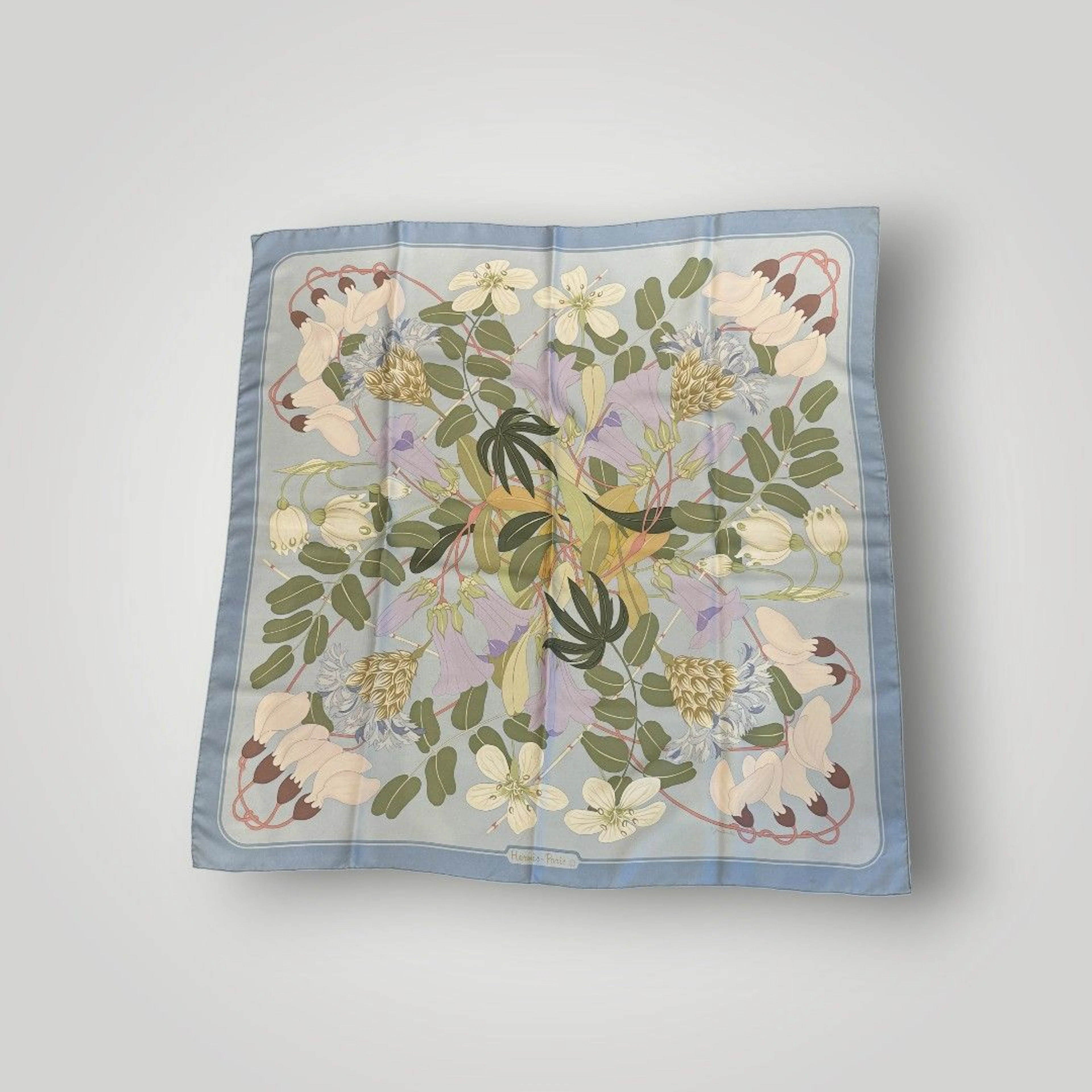 HERMES Foulard modèle " Fleurs tropicales " en twill de soie imprimée. Par N. FOULANCHIS. 90 x 90 cm. Quelques taches et trous.