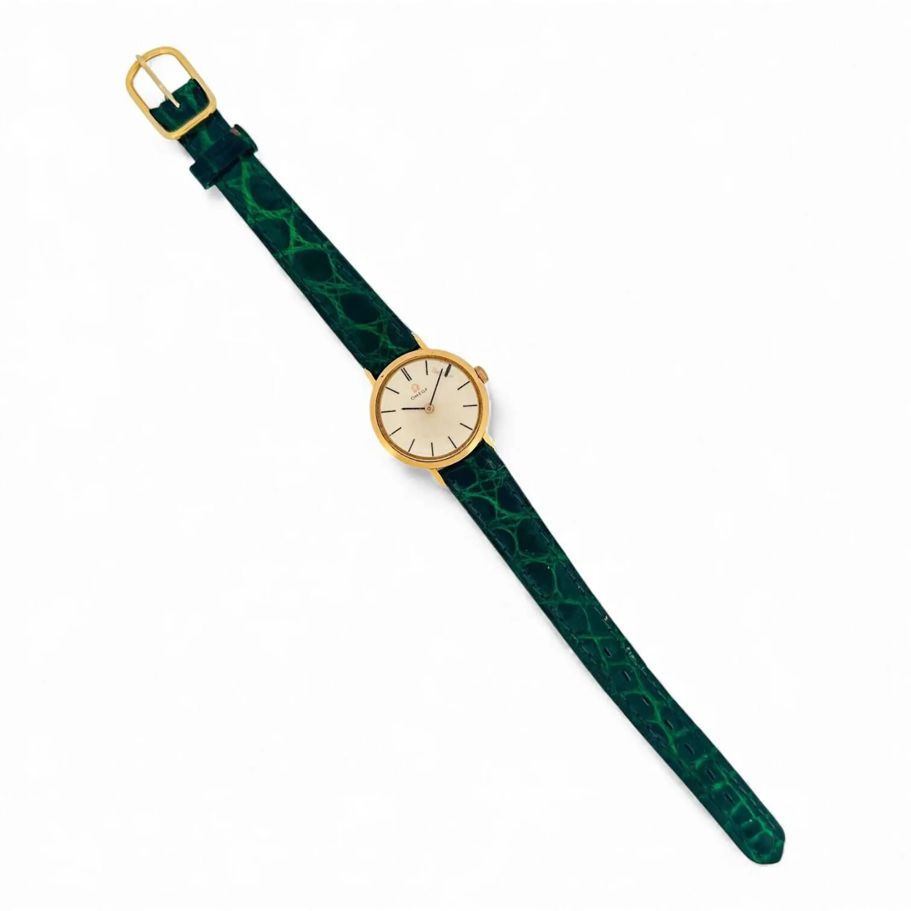 OMEGA Montre bracelet de dame en or 18K (750 millièmes), cadran argenté, index en appliques dorées et insert noir, aiguilles fils dorées peintes noires. Fond clipé en or 18K (750 millièmes), à l’intérieur signé Omega, poinçon de maître Jules Person. Mouvement mécanique à remontage manuel signé Omega calibre 620. Bracelet en cuir, boucle ardillon en métal doré. Montre fonctionnelle lors de l’expertise, sans garantie de fonctionnement futur et d’état des pièces. Rayures au boitier et au verre, quelques marques au cadran. Travail français vers 1965 Poids brut 15 g Diamètre 23 mm