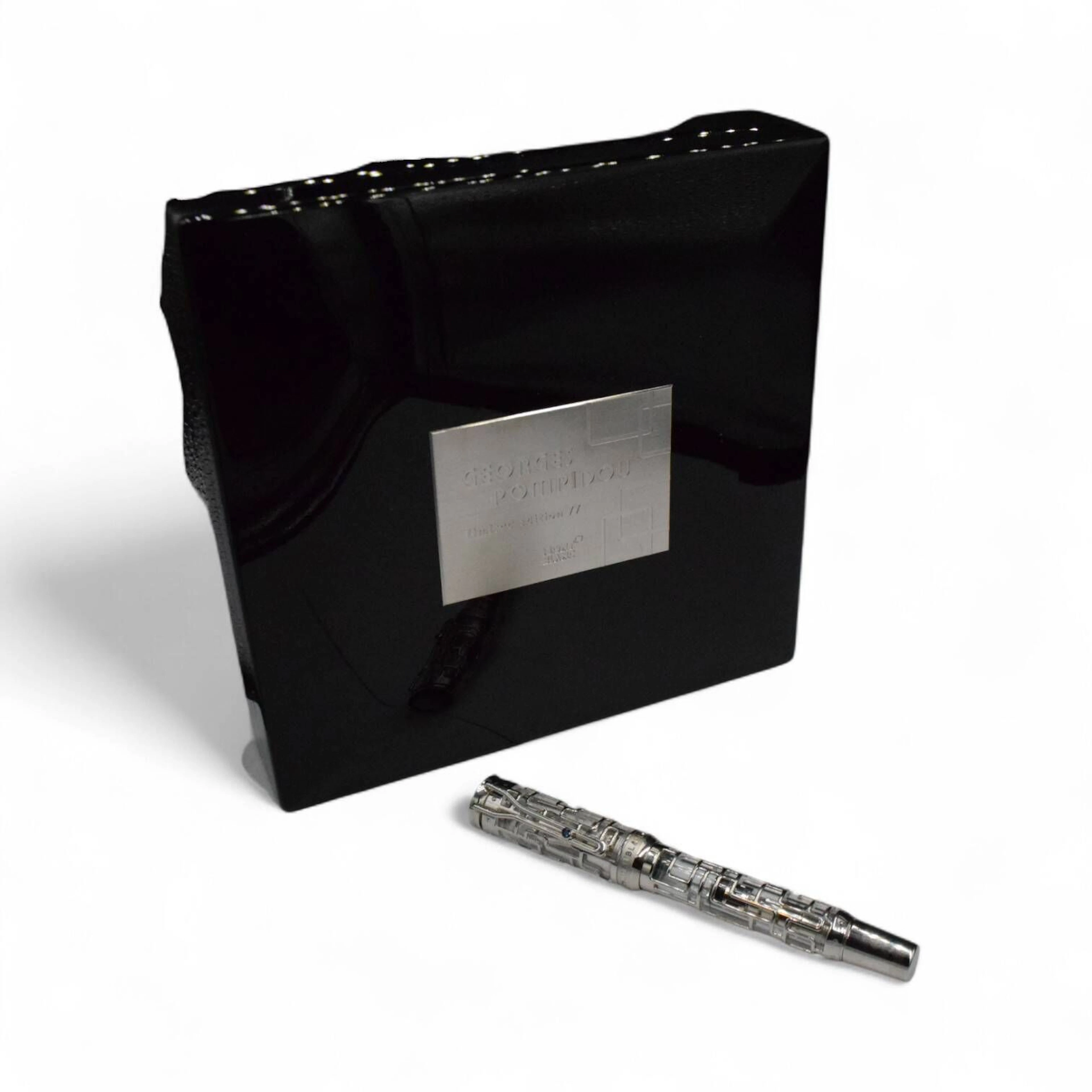 MONTBLANC "Georges Pompidou Skeleton 77" Stylo plume en or blanc 18k (750), rehaussés d'incrustations de diamants taille brillant. Le clip est serti d'un saphir, et l'emblème de la marque en nacre orne le sommet du capuchon. La plume en or blanc est gravée d'un portrait de Georges Pompidou. Système de remplissage à piston. Edition limitée n° 31/77, circa 2007 ; Longueur : 14,1 cm Avec sa surboite, boite, coffret, et documentations. Superbe.