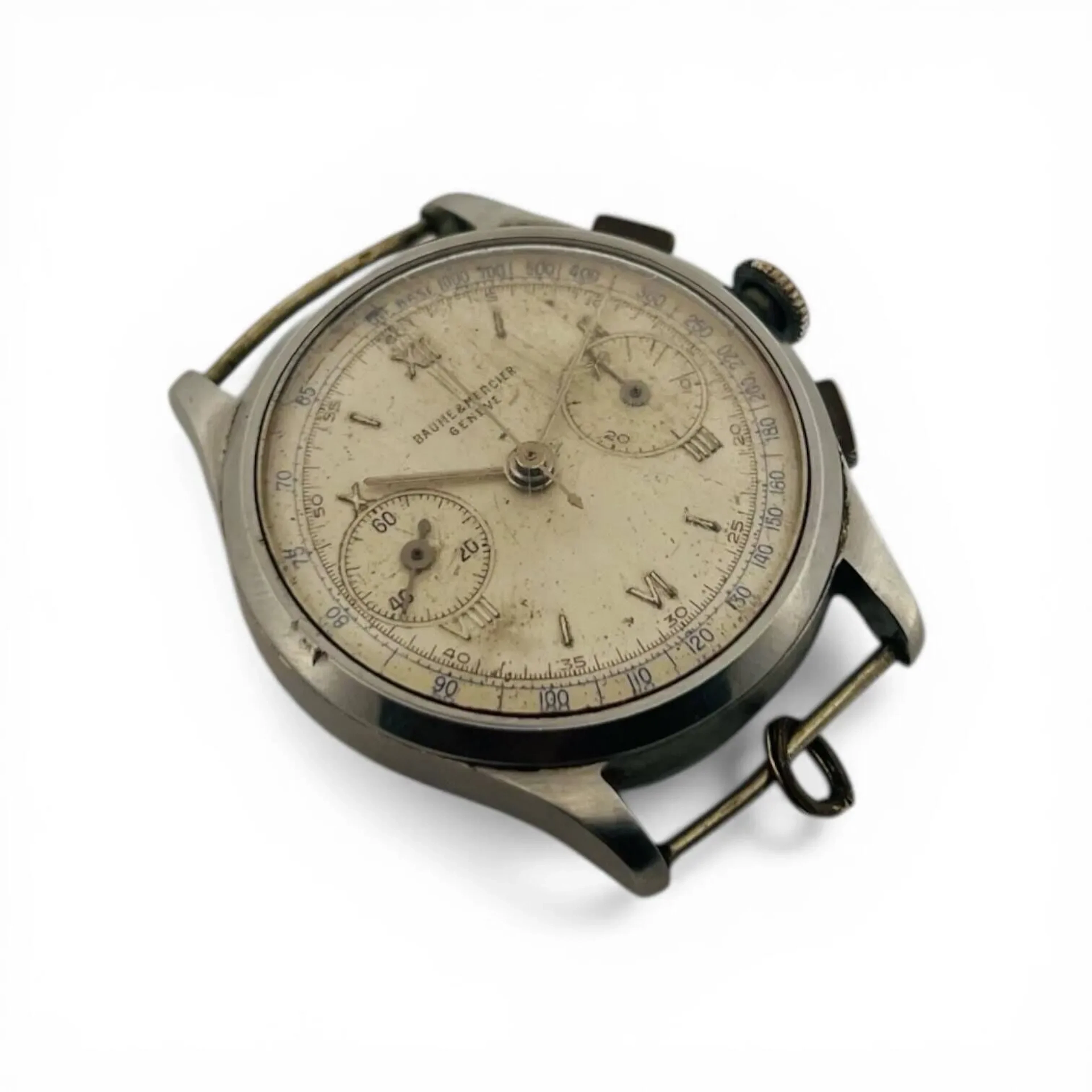 BAUME & MERCIER GENÈVE Montre-bracelet chronographe en acier, cadran opalin, minuterie à traits noirs, échelle tachymétrique bleue, index des heures chiffres romains en appliques argentées, petite seconde à neuf heures, totalisateur des 30 minutes du chronographe à trois heures, aiguilles fils argentées. Fond clipé en acier signé Baume & Mercier, à l’intérieur numéroté 338691. Mouvement mécanique de chronographe à remontage manuel. Montre fonctionnelle et chronographe non fonctionnel lors de l’expertise, sans garantie de fonctionnement futur et d’état des pièces. Rayures importantes au boitier et au verre, traces d’oxydation au cadran. Vers 1960 Diamètre 34 mm