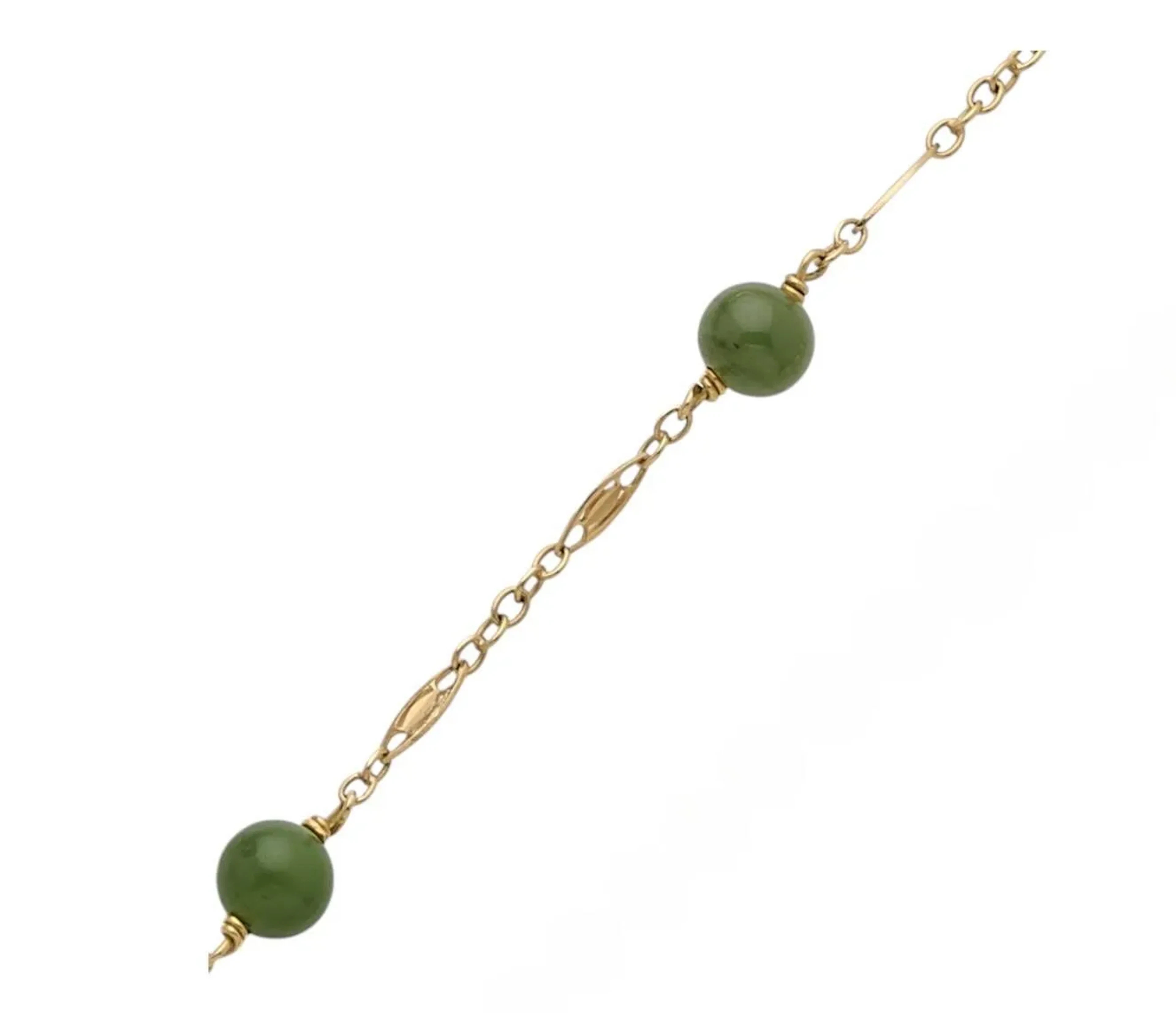 Collier en or 18K (750), articulé de maillons filigranés, scandé de billes de jade en chute. Longueur : 79 cm environ. Poids brut : 21,6 g