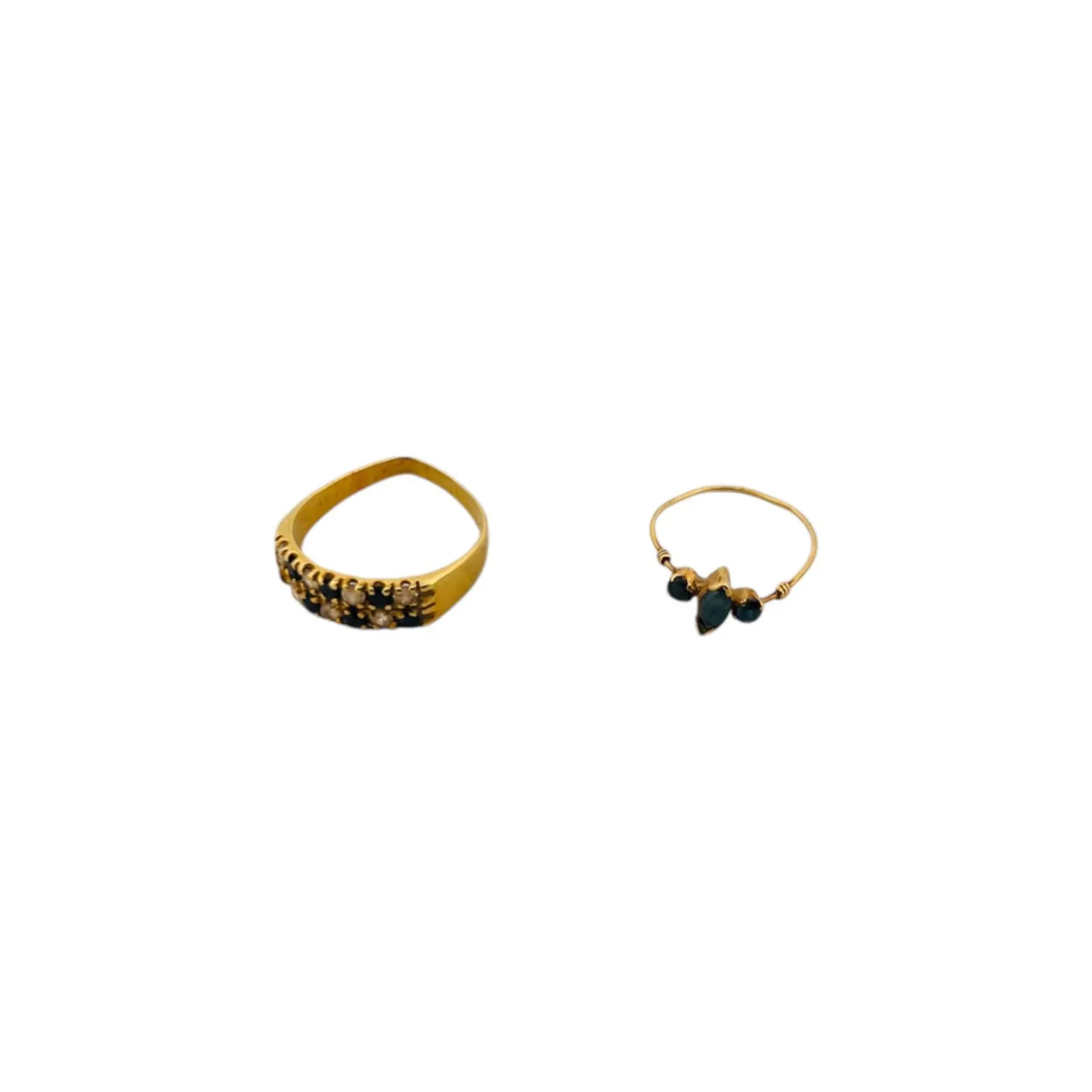 Suite de deux bagues en or 18K (750) comprenant une fine bague en fil d'or sertie d'un saphir navette épaulé de deux saphirs ronds et une alliance sertie d'un pavage de diamants et de pierres bleues. Poids brut : 3.62 g. (déformations et manques)