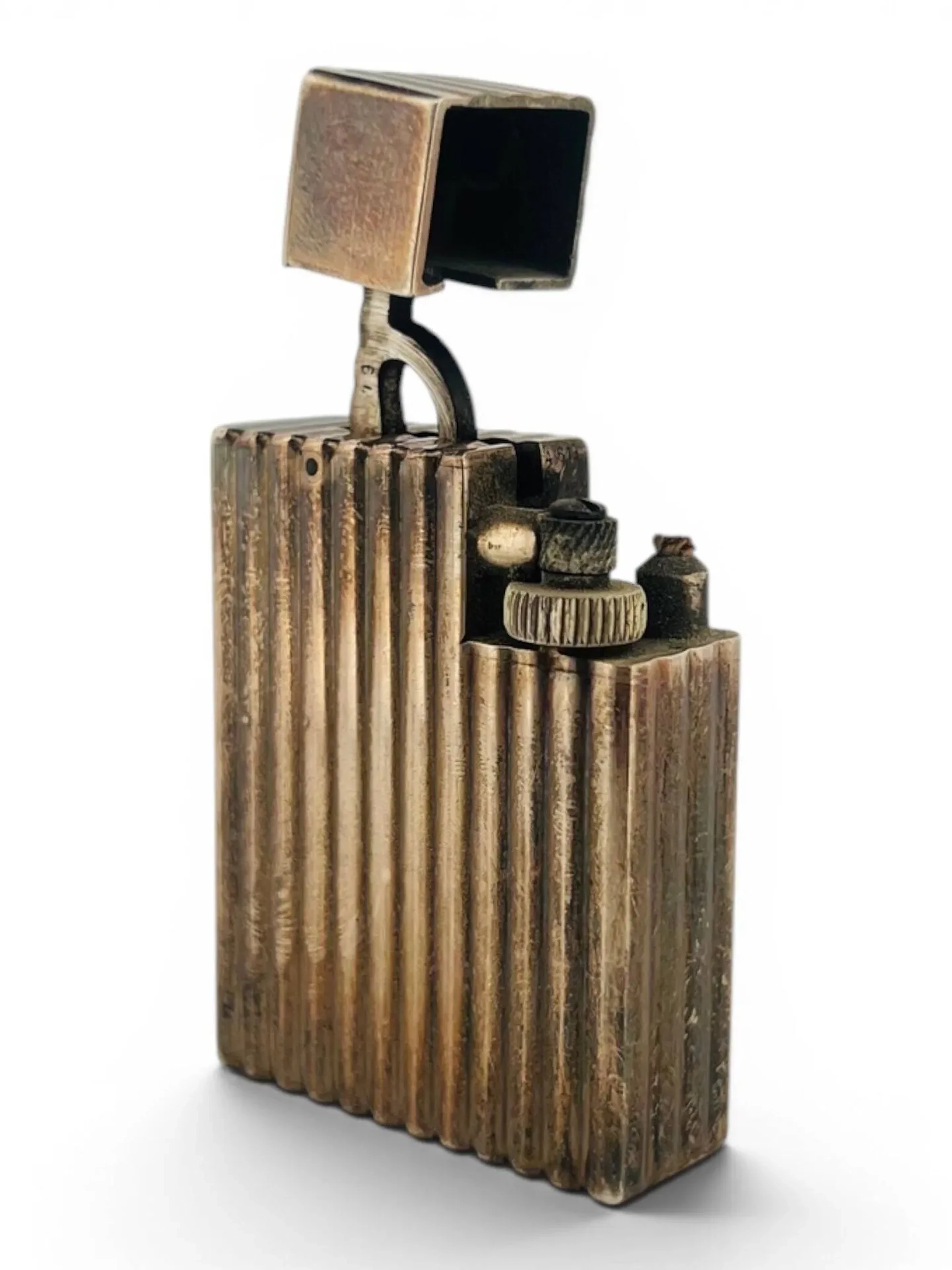 Cartier Briquet rectangulaire à cannelures, en métal argenté. Signé sous la base Cartier Paris. 45 x 35 x 12 mm Etat d'usage.