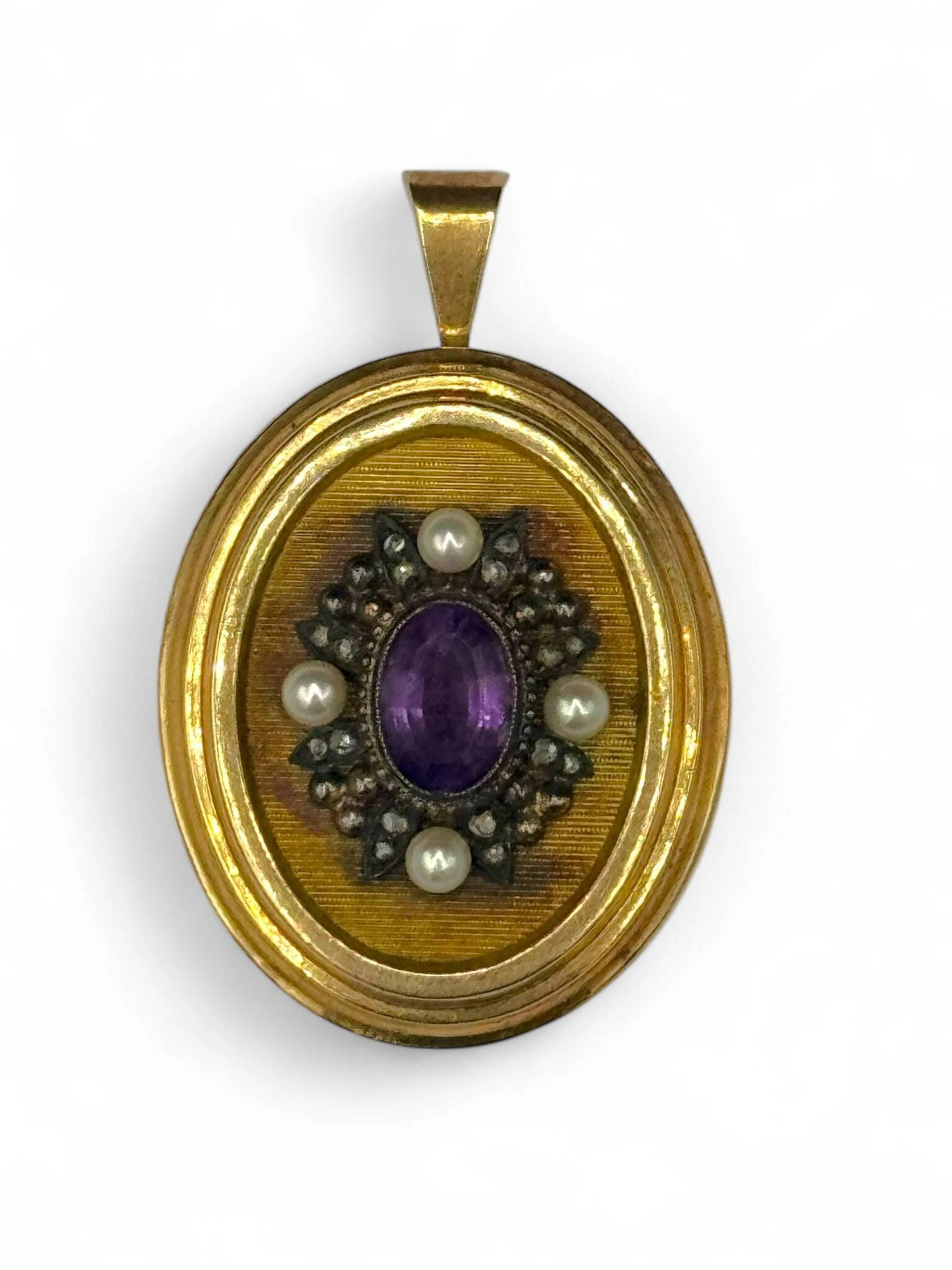 Broche pendentif en or jaune 18K (750) appliqué d'un élément en argent sertie d'une pierre de synthèse violette dans un entourage de quatre perles. Poids brut : 9.92 g.