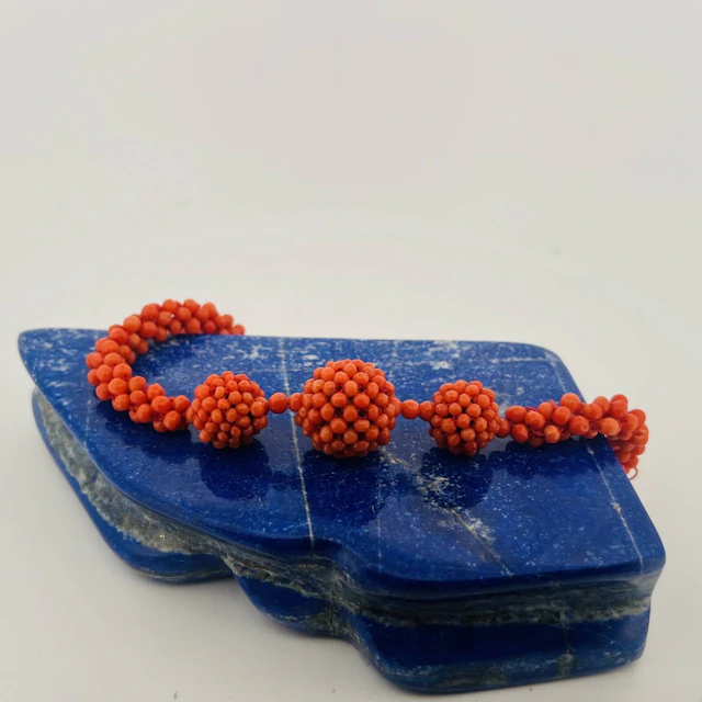 Braided coral bead necklace holding three spheres. Clasp in - Lot 328