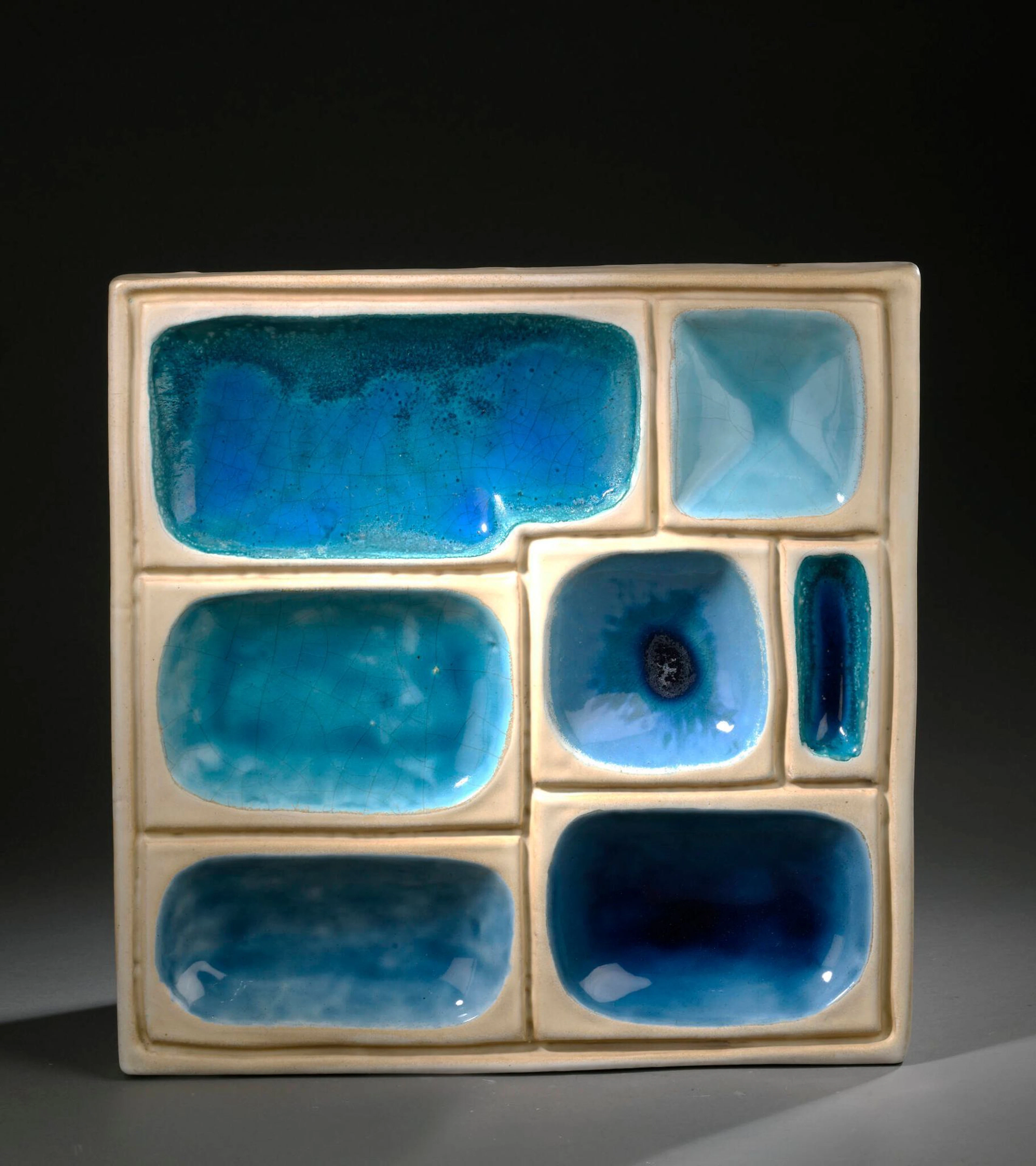 Georges JOUVE (1910-1964) Bas-relief, circa 1954 de forme carrée à décor géométrique en creux Épreuve en céramique émaillée blanc et bleu Signé Jouve et porte le sigle alpha de l’artiste H. : 44 cm. L. : 43 P. : 4 cm. (Usures, défauts d’émaillage et légères altérations) Bibliographie : - Georges Jouve, Edition Jousse entreprise, 2005, modèle à rapprocher reproduit p. 249.