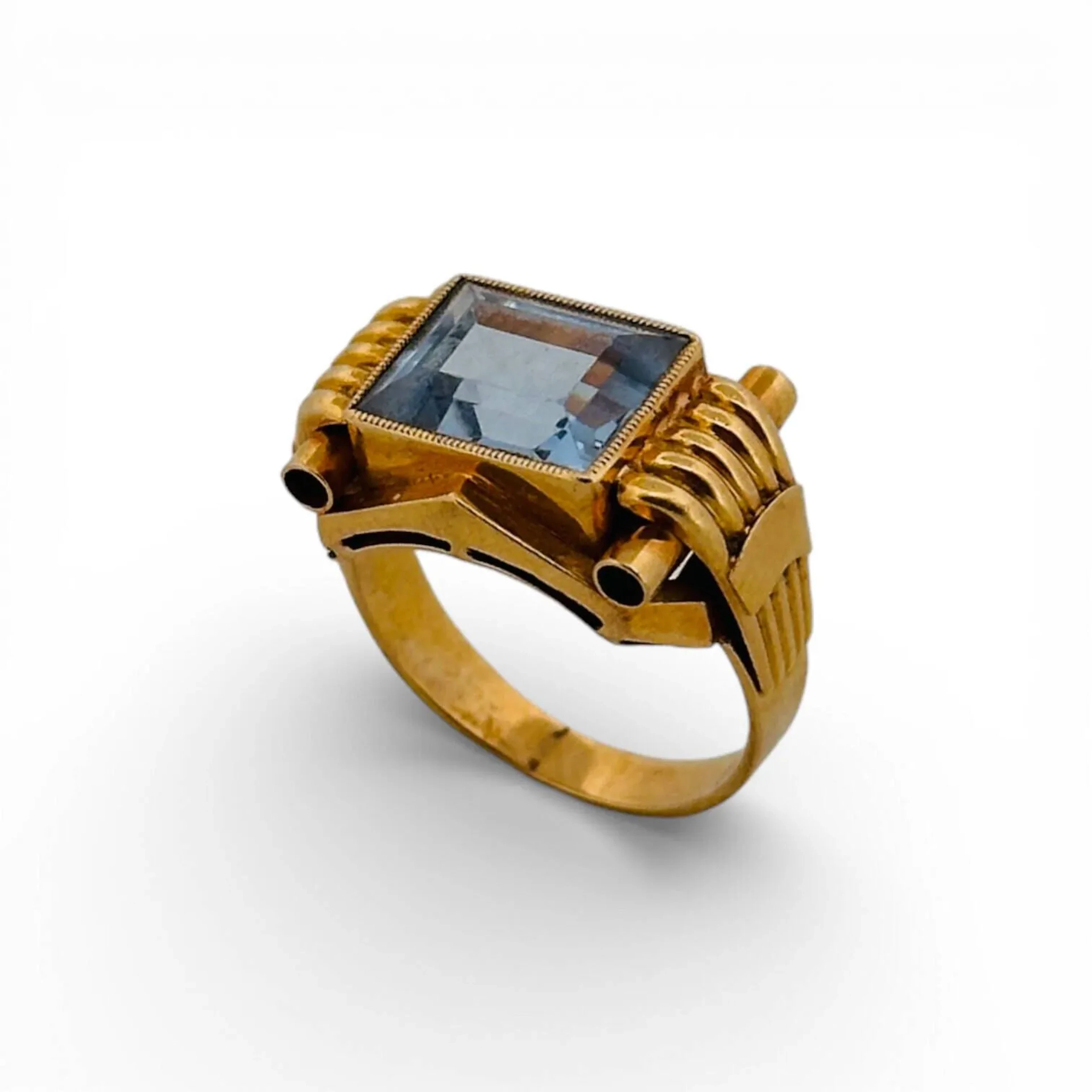 Bague tank en or jaune 18K (750 millièmes) centrée d'une importante spinelle synthétique épaulée de deux motifs incurvés Poids brut : 4.6 g TDD : 50 Poinçon tête d'aigle