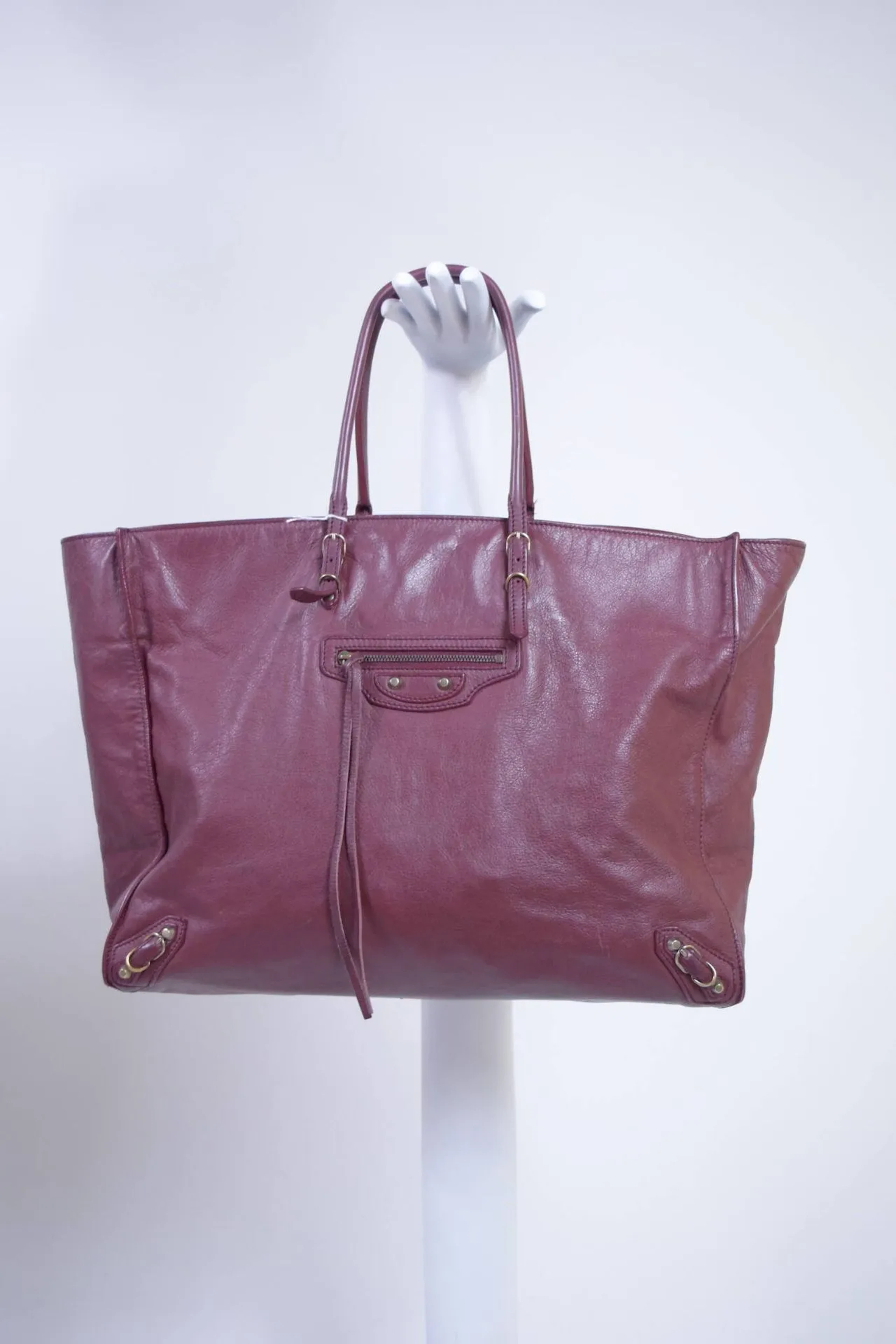 BALENCIAGA par Alexander Wang Circa 2013/2014 Sac modèle "Papier" porté main ou épaule en cuir grainé bordeaux. Bijouterie champagne. Intérieur daim. Frottements, légères usures aux angles. Dimensions : - Longueur : 38cm - Hauteur : 30cm - Largeur : 15cm - Hauteur de chute : 15cm