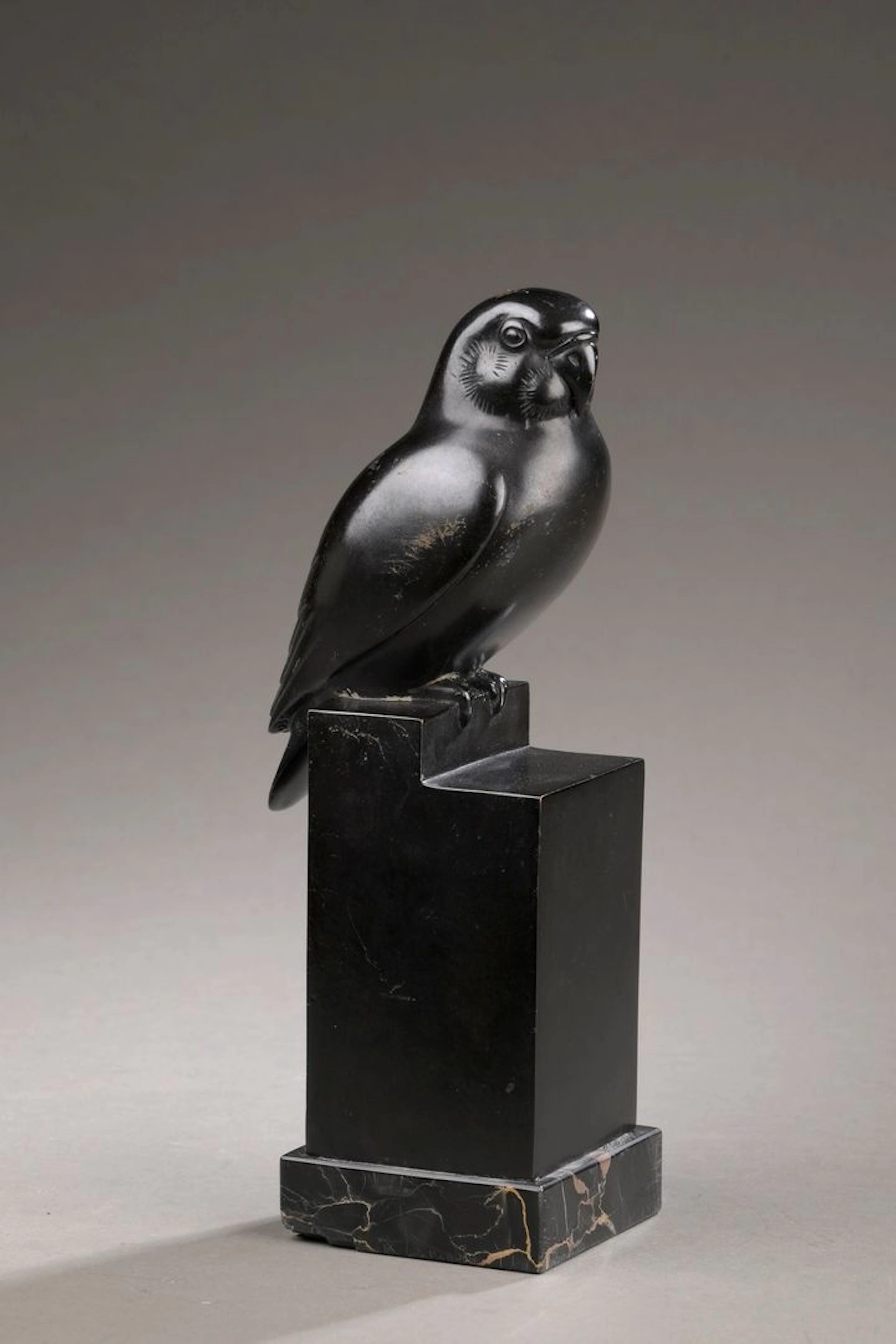 PETERSEN Armand, 1891-1969 Perroquet sur socle perchoir cubique, taille 2 bronze à patine noire sur socle en marbre noir veiné de beige, fonte à la CIRE PERDUE E ROBECCHI (petits manques au socle, quelques accidents à la patine) sur le côté de la terrasse : A. PETERSEN, sur l’arrière la marque du fondeur Ht. : 24,3 cm + socle BIBLIOGRAPHIE : - Liliane Colas, Petersen, sculpteur animalier, éditions Finzi, Tunis, 2004, plâtre décrit et reproduit sous le n°69 pp.154-155. - Jean-Marc Bauquier, Armand Petersen, œuvres complètes 2024, éditions Books Factory, 2024, plâtre blanc décrit et reproduit sous le n°69.2 p.216. Nous remercions M. Bauquier pour les informations qu’il nous a communiquées. Un certificat de l’Association AAPEA pourra être réalisé aux frais de l’acquéreur