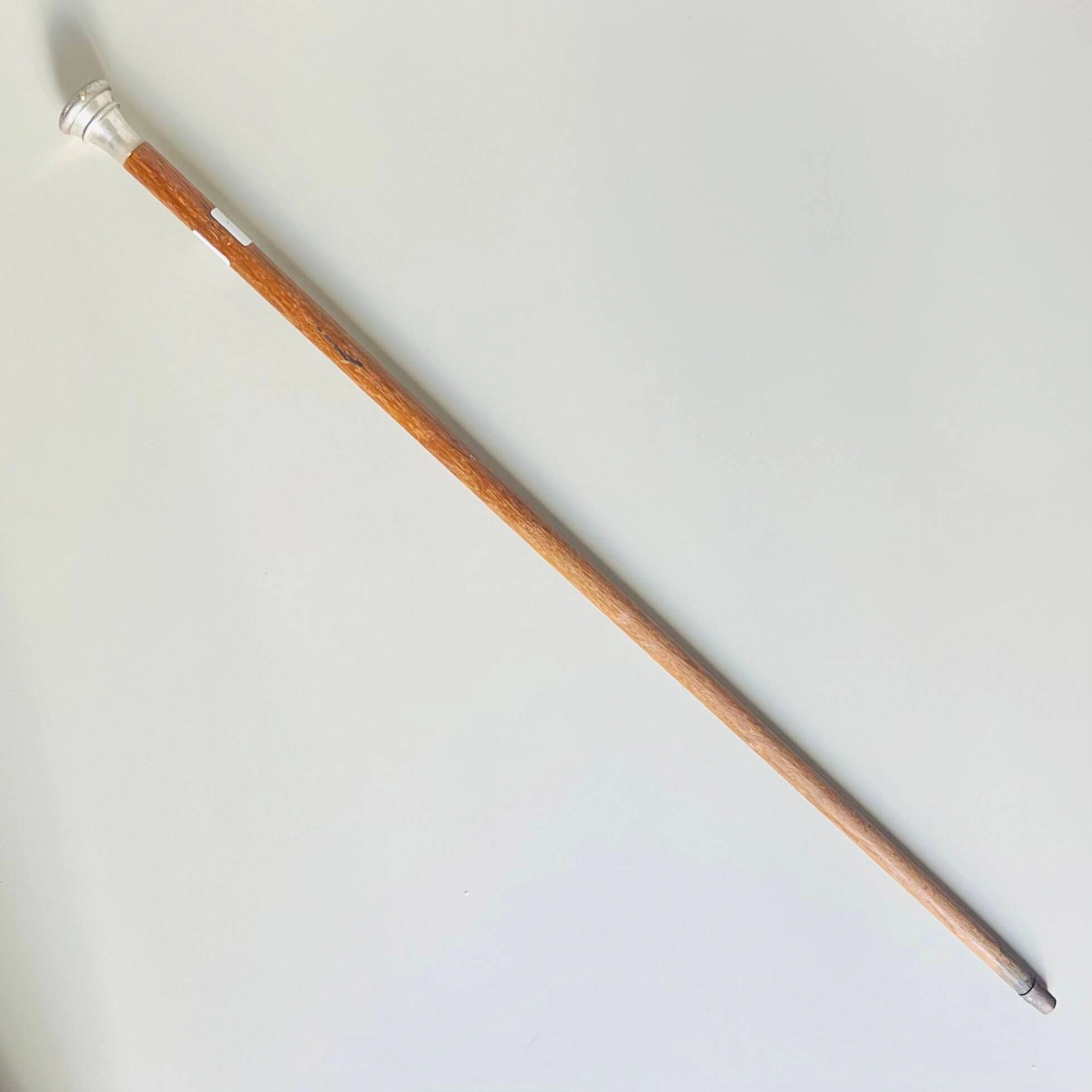 Canne à système porte-montre en bois, le pommeau à monture en métal argenté sommé d'une montre à gousset en argent (925) à cadran émaillé blanc, chiffres romains pour les heures et chemin de fer. Le boîtier à décor ciselé de motifs stylisés. Cuvette et cache-poussière en argent (925) numérotés 28787. Mouvement mécanique à remontage à clefs Birmingham, 1882 Long. canne: 82,5 cm Poids brut total: 228 gr Usures au bois et au métal, rouille et désargenter à la monture. Montre non fonctionnelle au moment de l'expertise.
