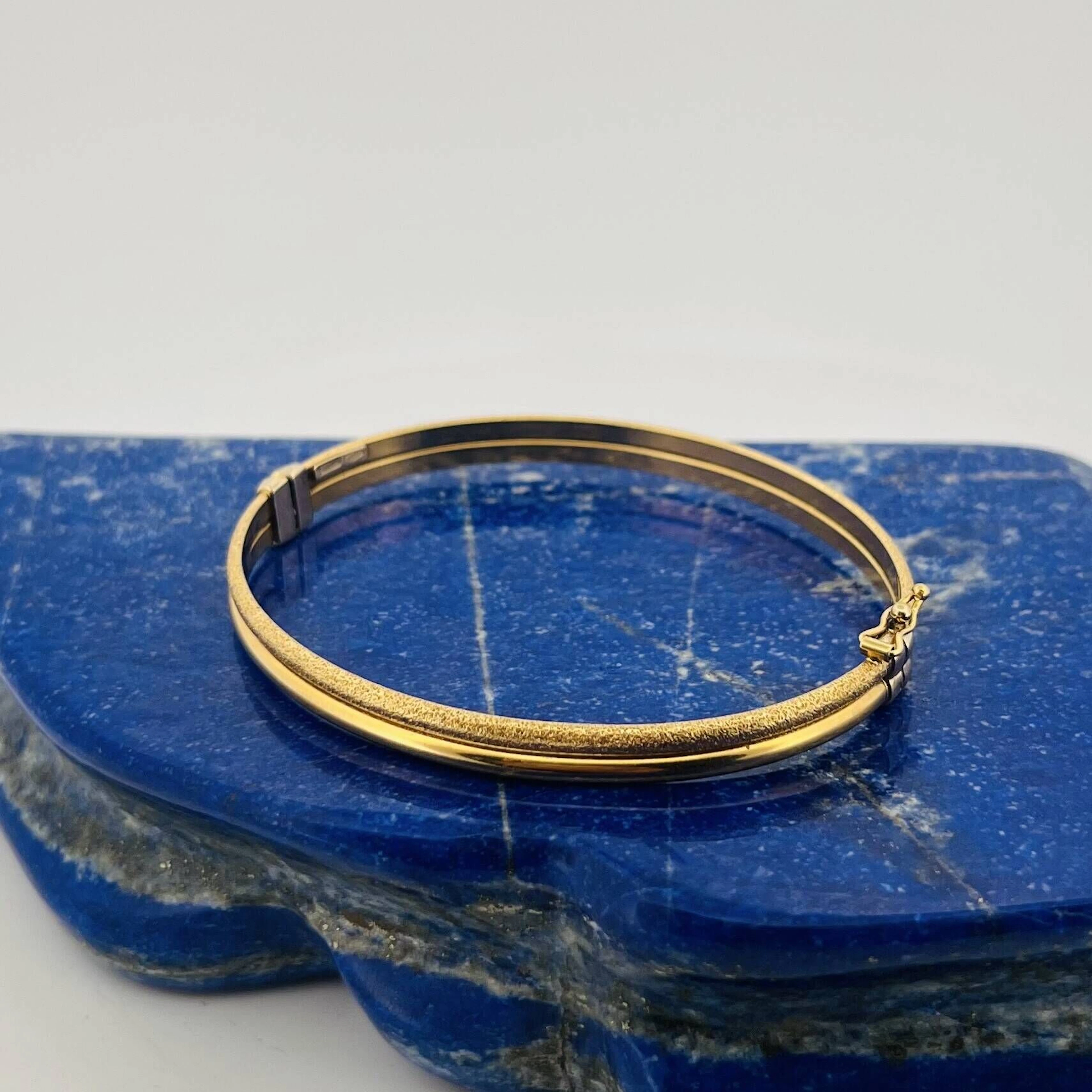 Partially guilloché yellow gold (750) bangle with a clasp. D - Lot 261