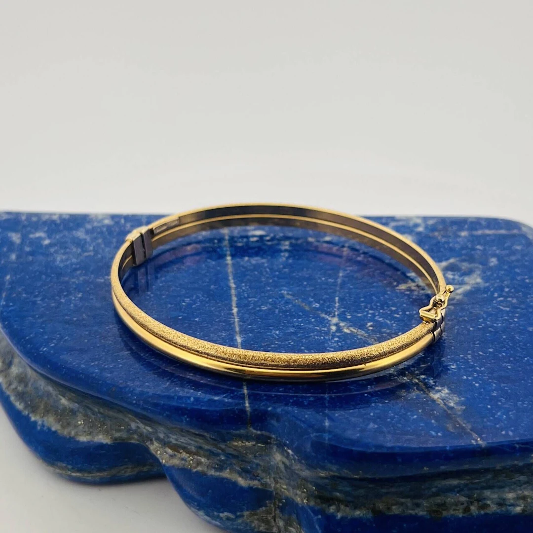 Partially guilloché yellow gold (750) bangle with a clasp. D - Lot 261