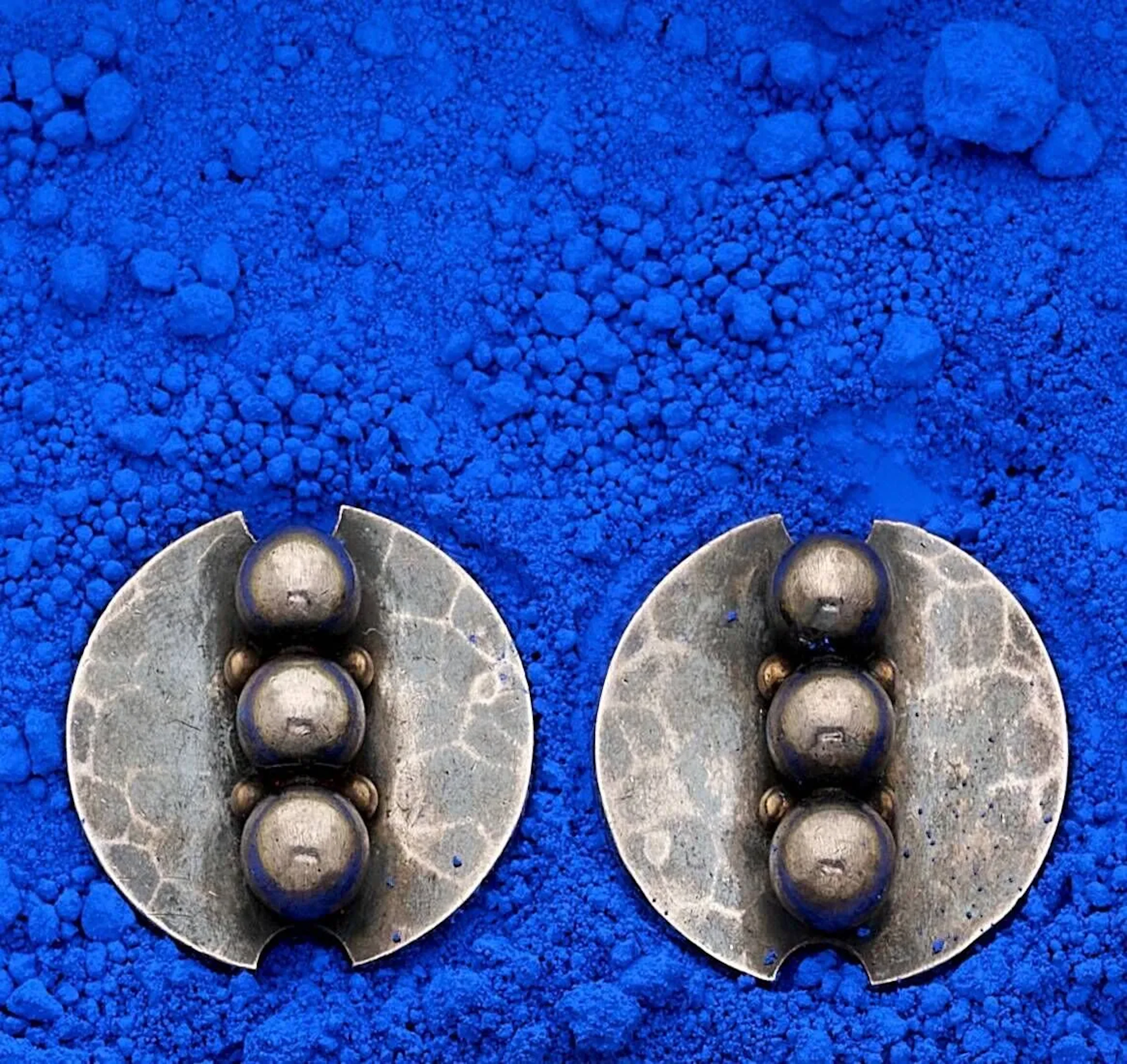 Jean DESPRÉS (1889 – 1980) Paire de boucles d’oreille en argent à corps circulaire décoré de trois sphères en partie centrale sur fond martelé. Signées en toutes lettres, poinçon d’orfèvre et de matière sur chacune (tête de sanglier). Diam. 2,5 cm