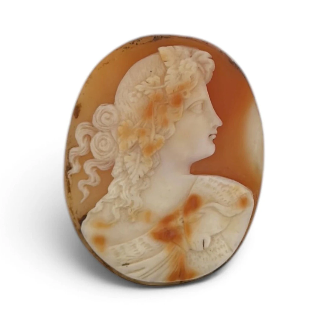 Oval shell cameo depicting the profile of a woman wearing a - Lot 165