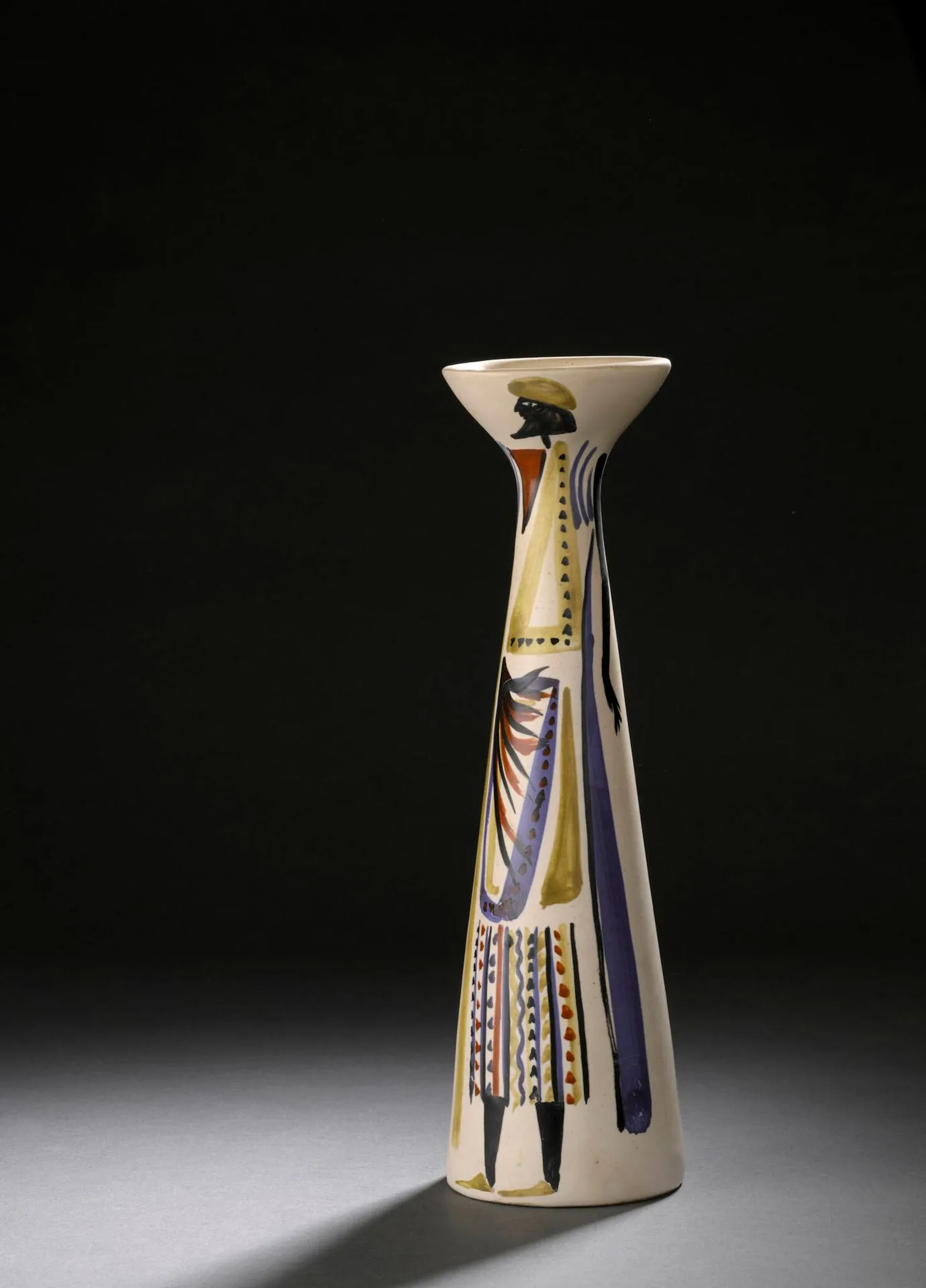 ROGER CAPRON (1922-2006) Vase diabolo modèle V11, circa 1955 Épreuve en faïence émaillée polychrome à décor d’un homme Signé Capron et situé Vallauris sur l’envers. H. : 31 cm. (Infime éclat en bordure de la base, traces de salissures) Bibliographie : - Pierre Staundenmeyer, Roger Capron Céramiste, Edition Norma, 2023, modèle similaire reproduit p. 186.