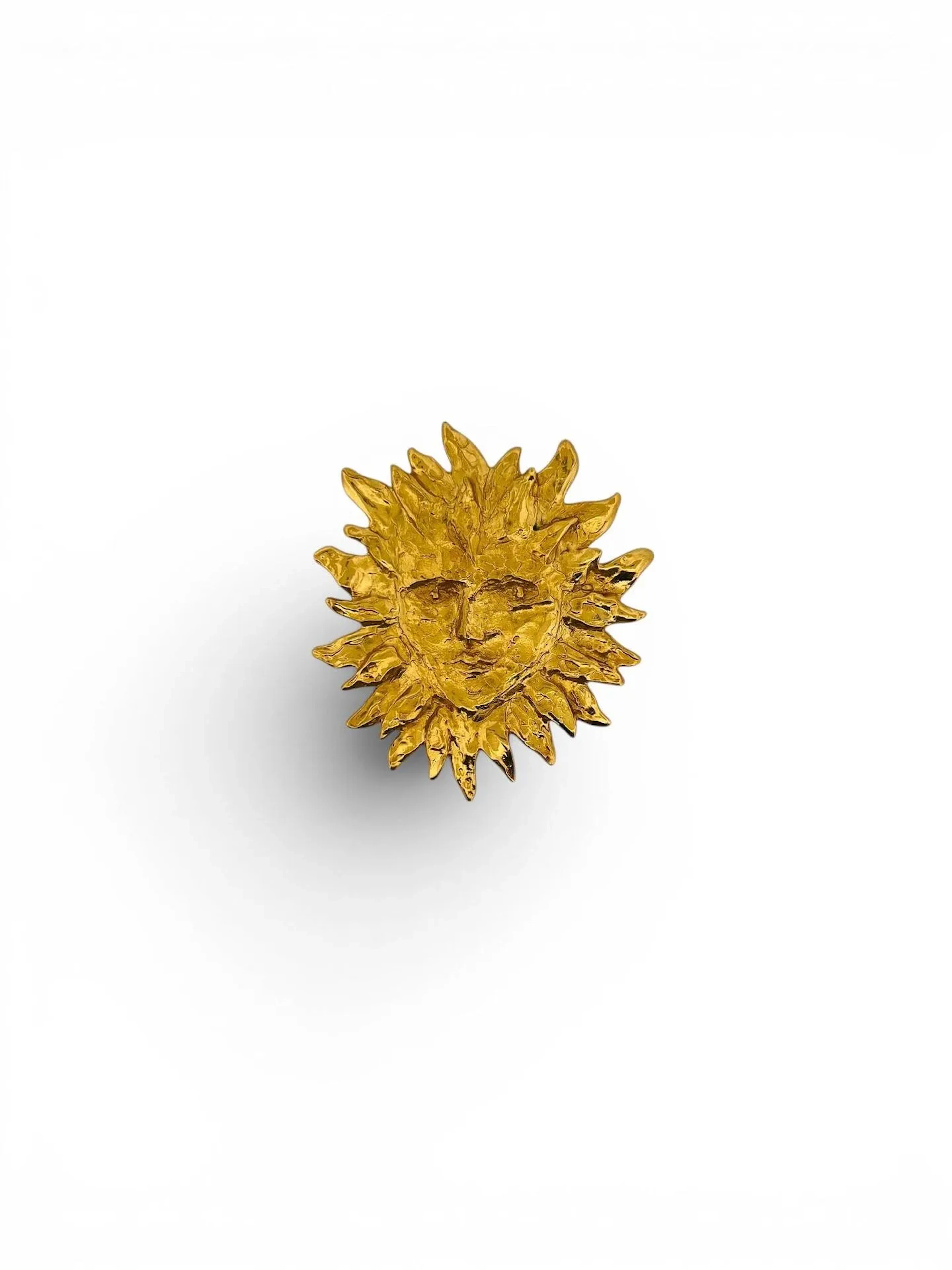 YVES SAINT LAURENT par Robert Goossens (1927-2016) Broche en métal doré gravé martelé figurant un soleil stylisé. Siglé 8 x 7,5 cm