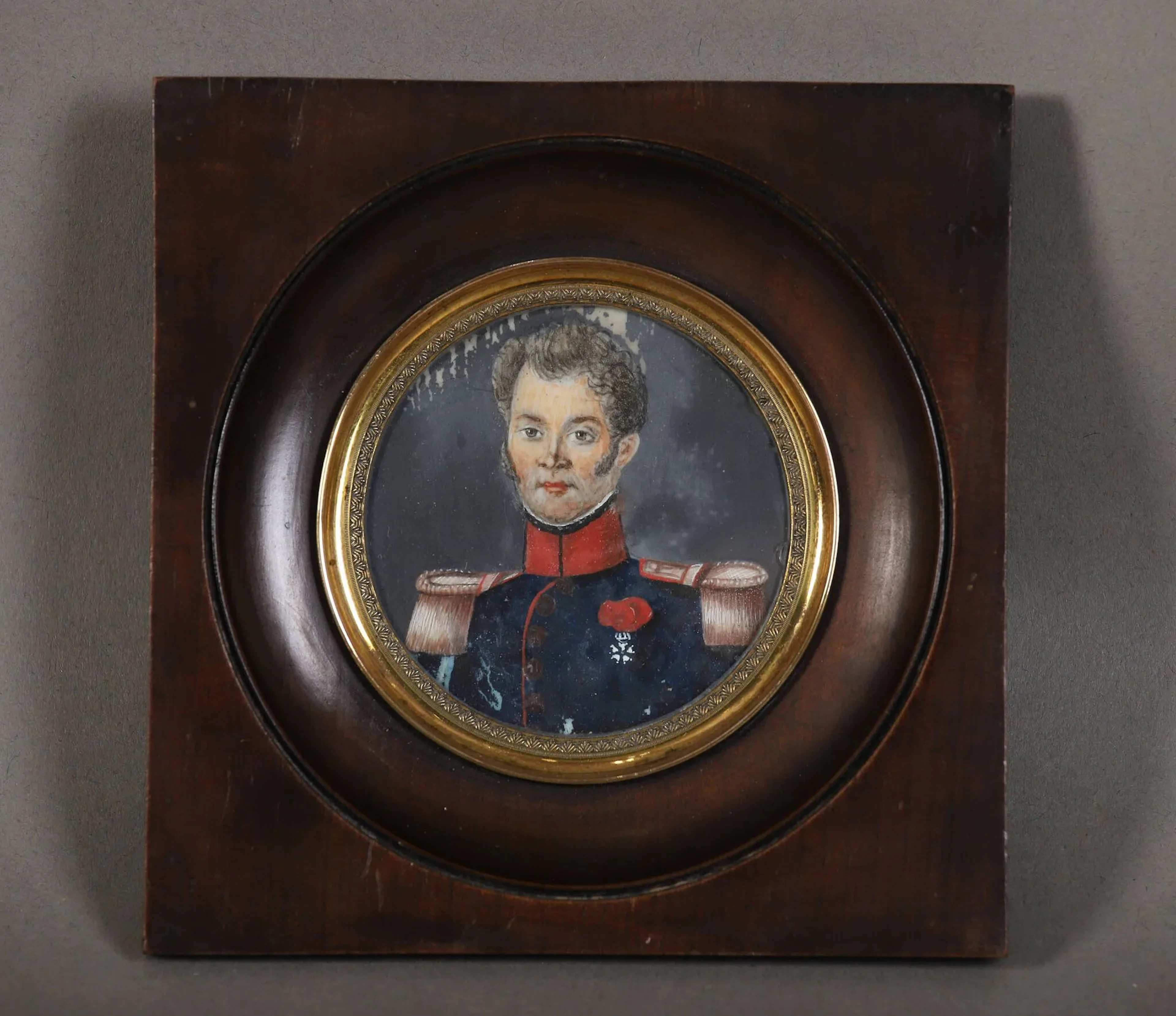 Miniature XIXème Tondo figurant un officier français en uniforme porteur de la Légion d'Honneur. Dans un encadrement carré en bois. Diam. : 6 cm - Décollements.