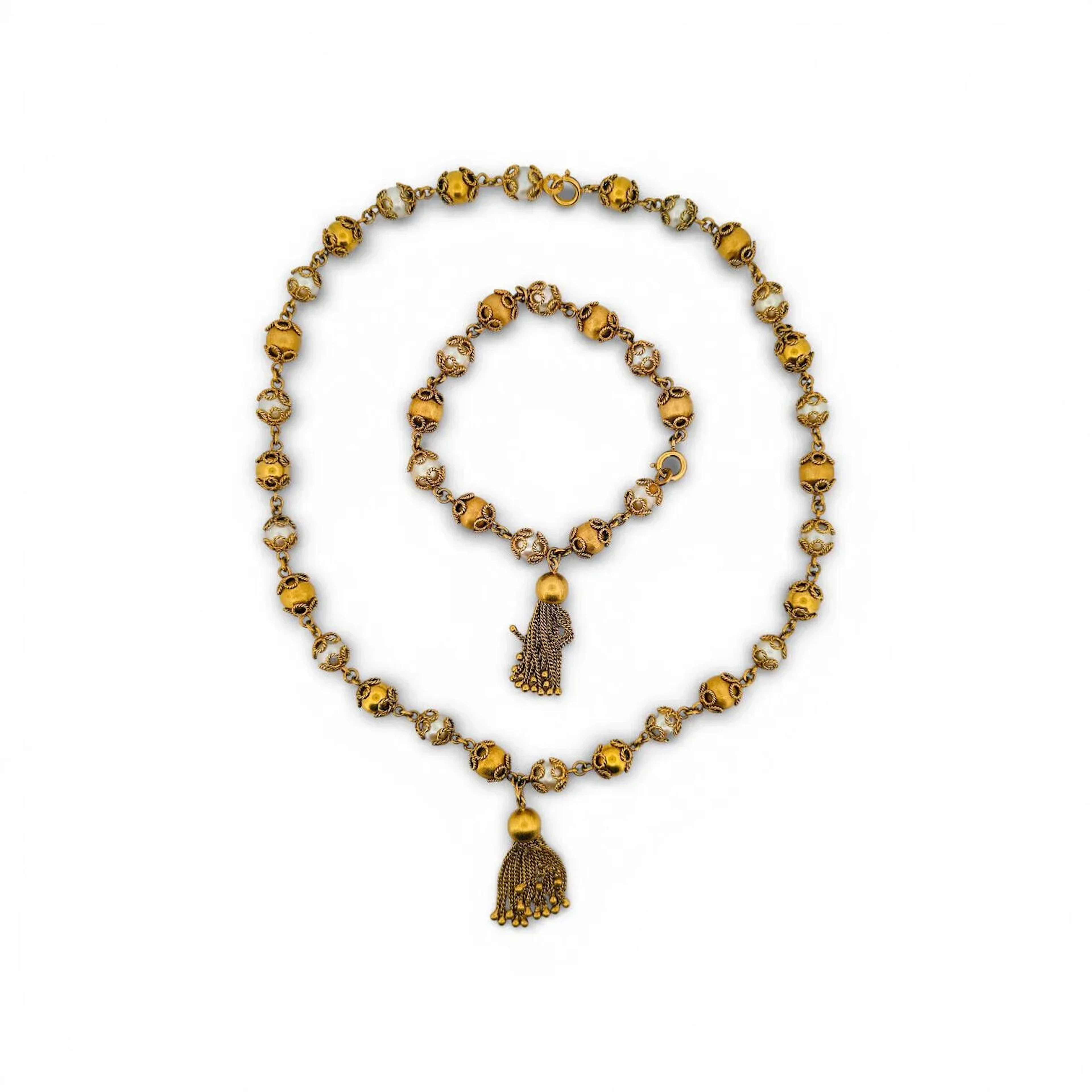 Collier et bracelet composés de perles de culture et calottes filigranées en or jaune 18K (750 millièmes) retenant un gland composé de multiples chainettes Poincons têtes d'aigles Poids brut total : 78.7 g
