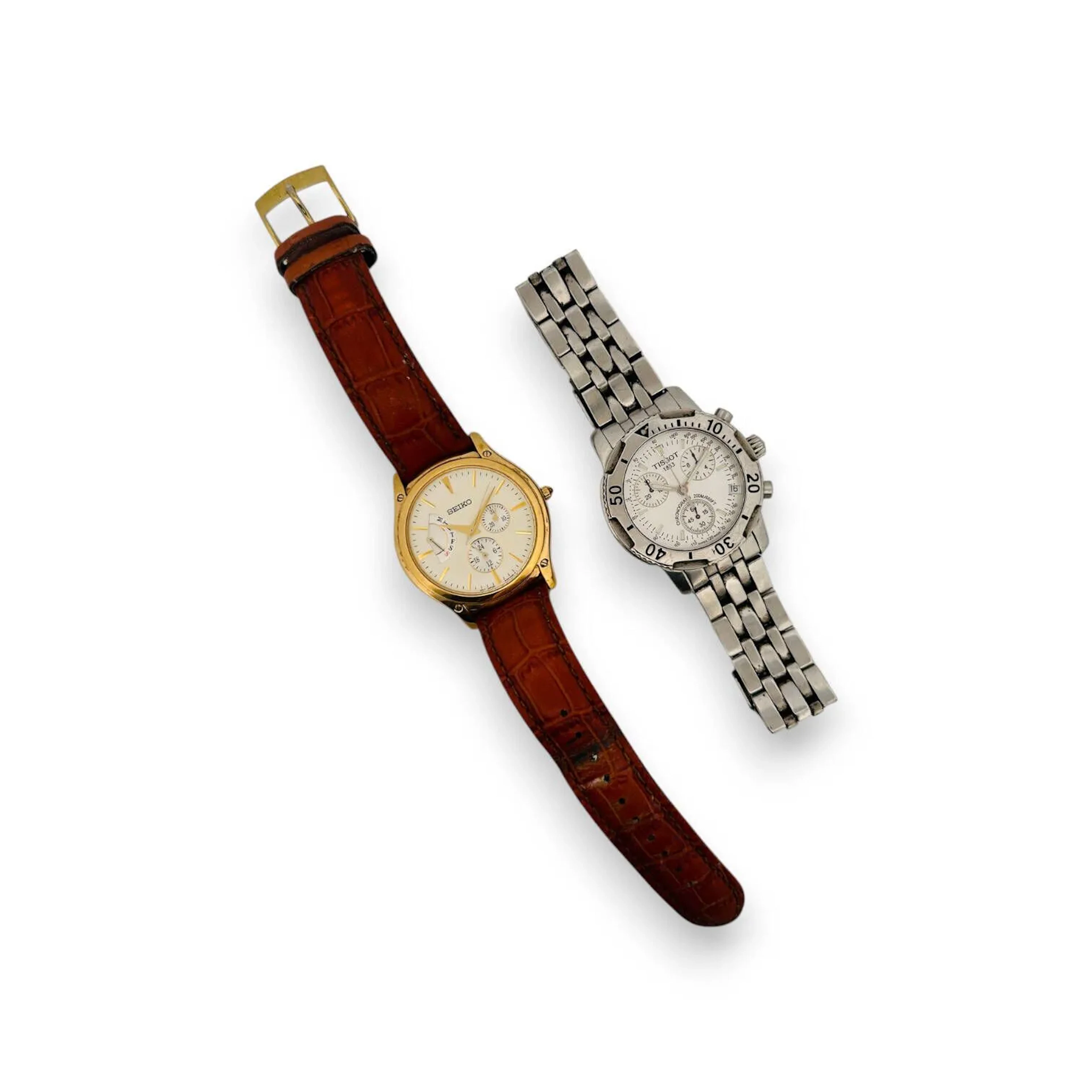 SEIKO-TISSOT Suite de deux montres bracelet pour homme comprenant : - une montre SEIKO, boitier en métal doré et acier, cadran crème, trois sous-cadrans, mouvement quartz (pile non vérifiée), bracelet intégré en cuir marron à boucle ardillon signée. Cadran et boitier signés. Boitier numéroté. Diam. : 40 mm. - une montre TISSOT PRS200, boitier en acier, cadran argenté, index bâtons formant les heures, trois-sous cadrans, date par guichet à 4h, mouvement quartz, bracelet intégré en acier à boucle déployante siglée. Cadran et boitier signés. Boitier numéroté. Diam. : 40 mm. Conservées dans une boite de la marque SEIKO. Vendues en l'état.