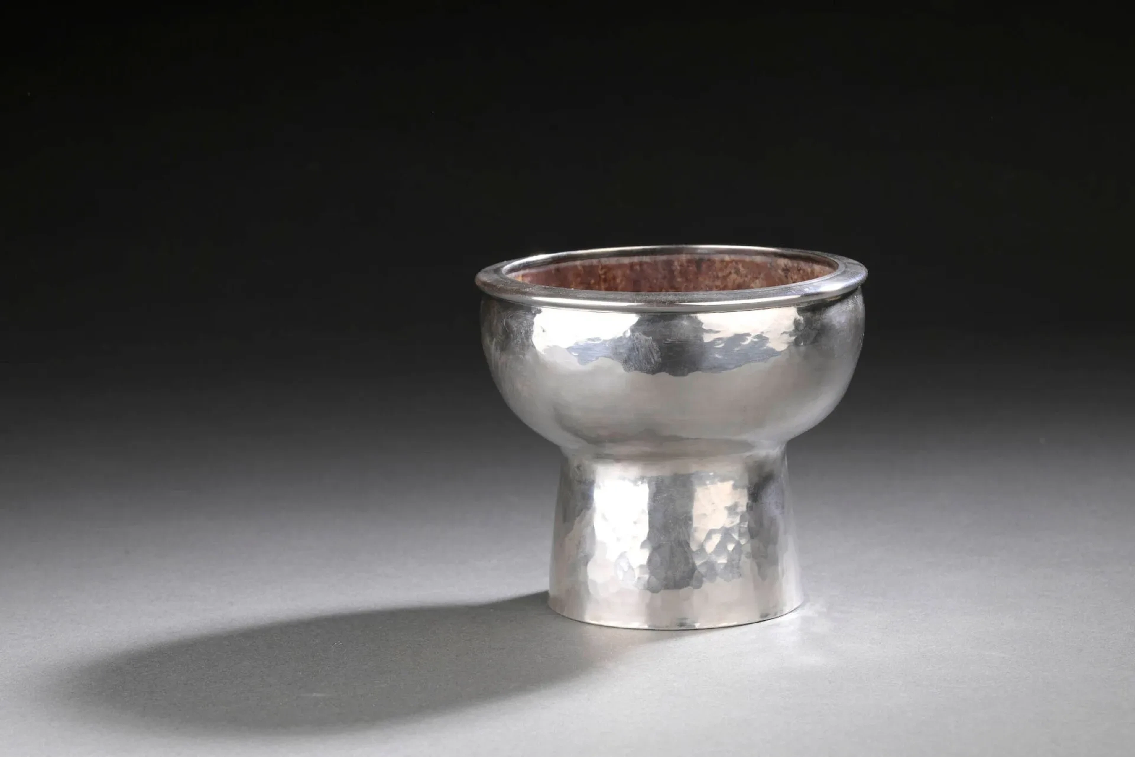 GOUDJI (né en 1941) [Guy Georges Amachoukeli dit] Coupe sur piédouche en argent martelé (925), l'intérieur en pierre dure. Signé en toutes lettres sur le dessous, initiales GA en caractères géorgiens et "PARIS". Titre: Minerve 1er titre (1838-1973), Maître orfèvre: GA différent deux marteaux. H. 9,5 - Diam. 11 cm Poids brut: 408,8 gr Infimes chocs