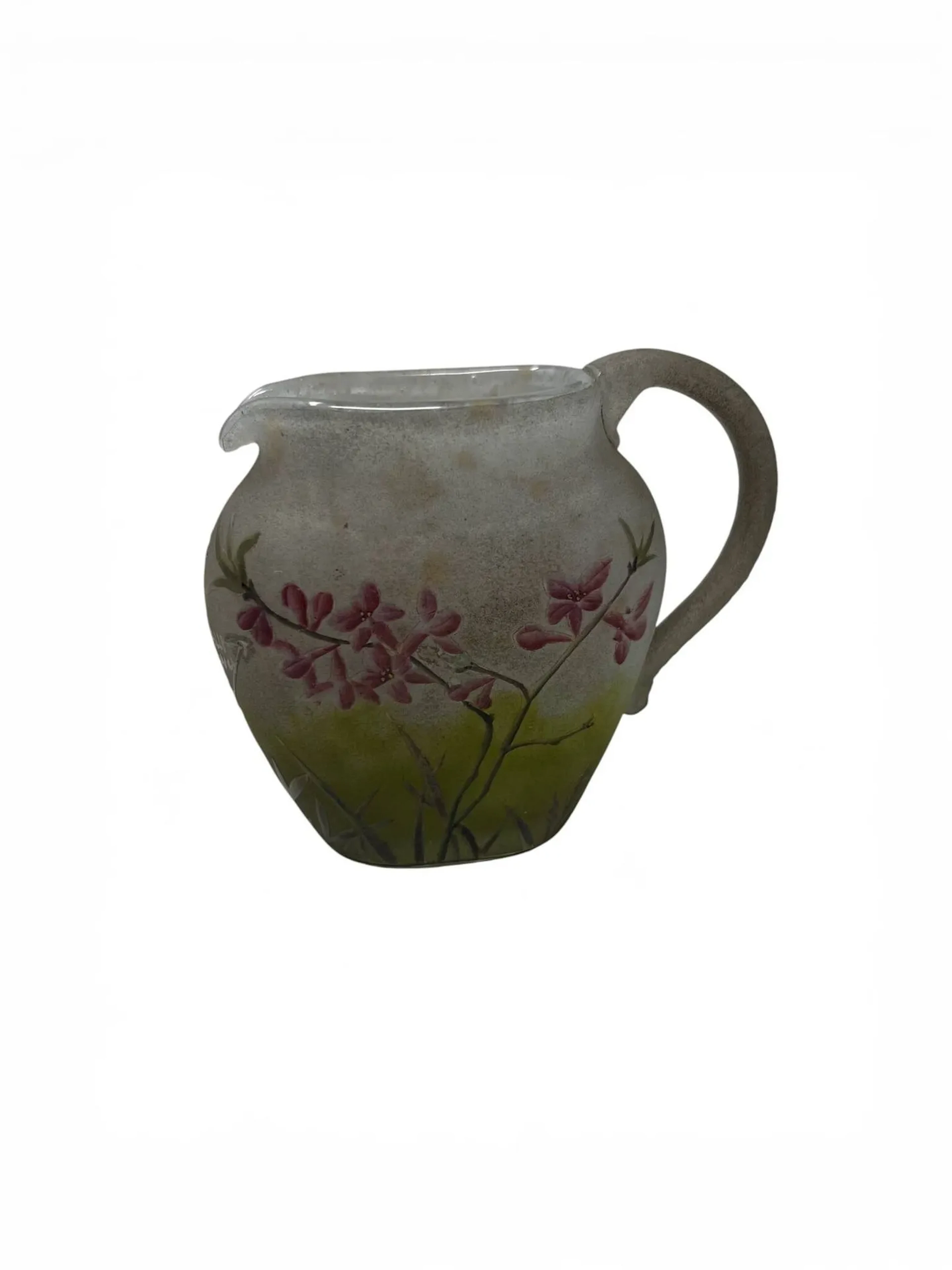 DAUM – NANCY Pichet miniature à corps ovoïde aplati, petit bec verseur et anse latérale détachée modelée à chaud en application. Épreuve en verre marmoréen vert blanchâtre. Décor de bois-joli gravé en réserve à l’acide et rehaussé d’émaux polychromes au naturel. Signé dans le décor. Haut. 8,5 cm