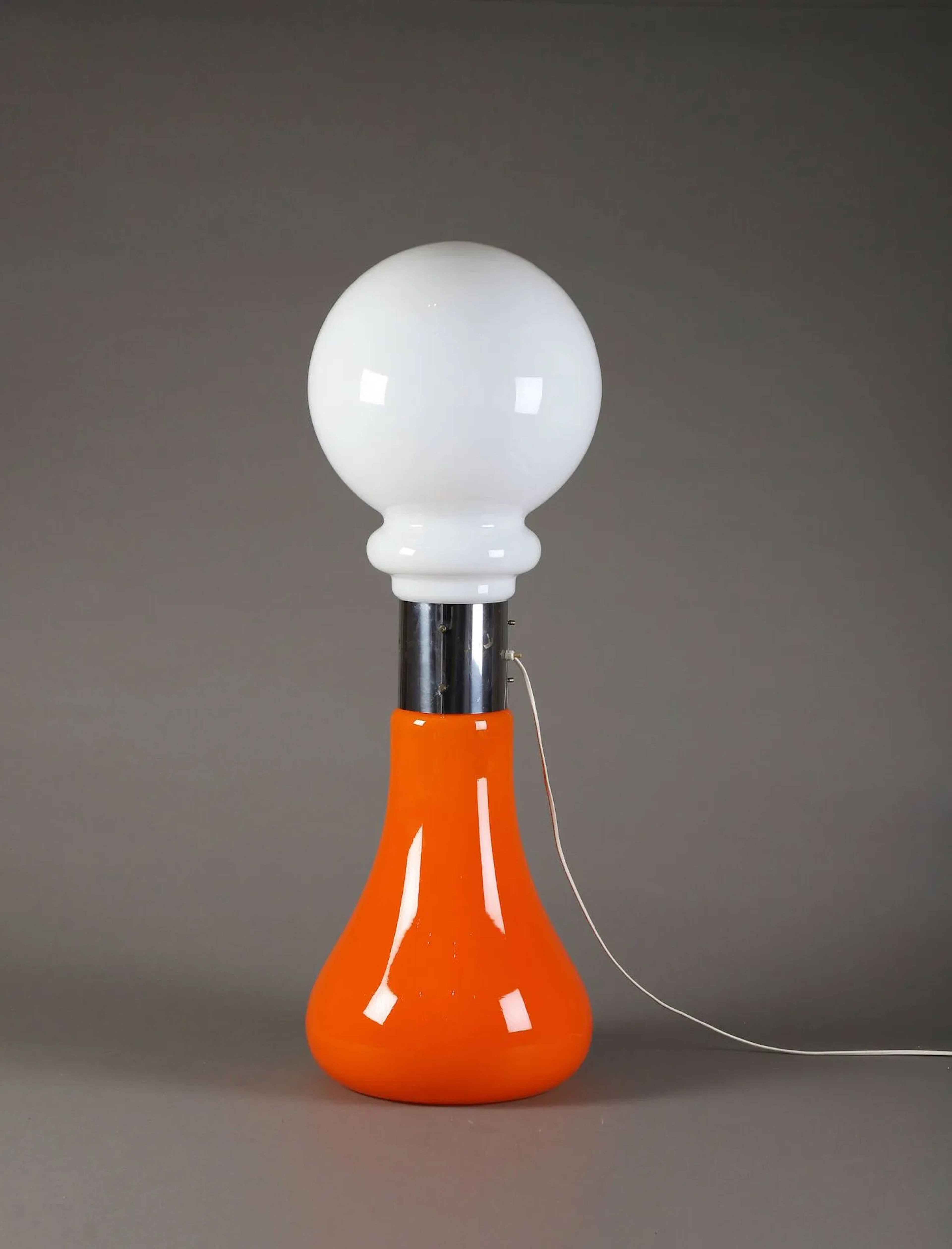 TRAVAIL ITALIEN (XX°) Lampadaire, circa 1960, à double diffuseur en verre opalin et orange réunies au centre par une bague cylindrique en acier. H. : 97 cm.