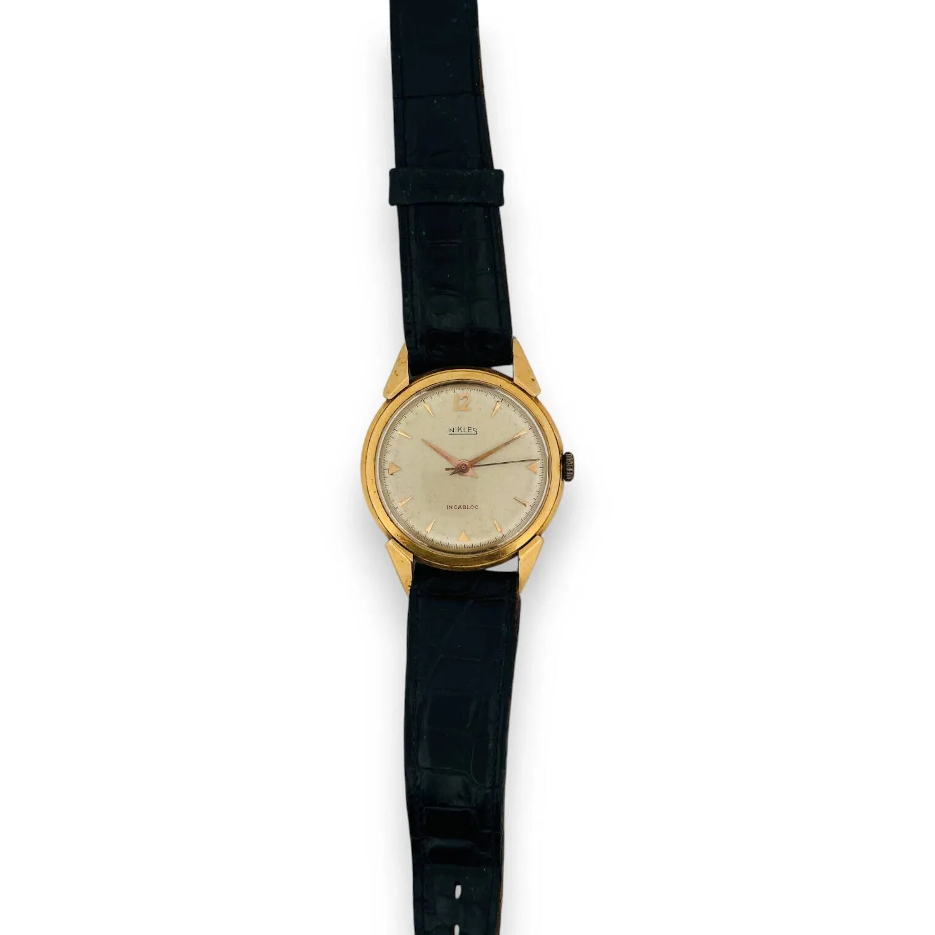 NIKLES Montre bracelet pour homme, boitier rond en or jaune 18K (750), cadran champagne, index trangles et bâtons dorés, mouvement mécanique, remontoir en métal, bracelet en cuir noir à boucle ardillon en métal. Diam. : 33 mm - Poids brut : 32.39 g.