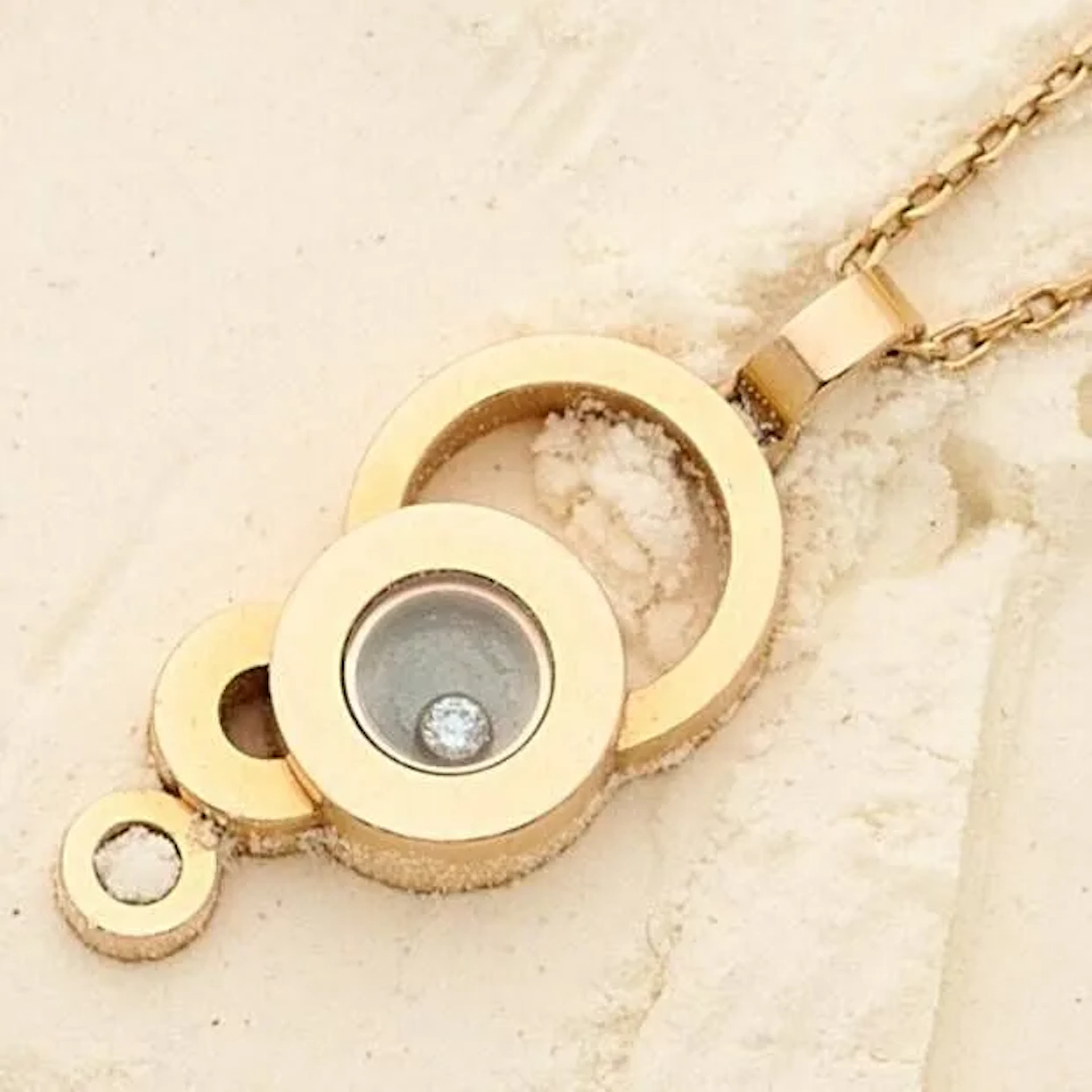 CHOPARD "Happy Diamonds" Collier en or gris 18k (750e), composé d'une chaîne maille forçat, retenant un pendentif stylisant des bulles dont une retenant un diamant mobile sous verre. Signés, numéroté. Poids brut : 9.70 g. Longueur : 46 cm. Hauteur : 3 cm.