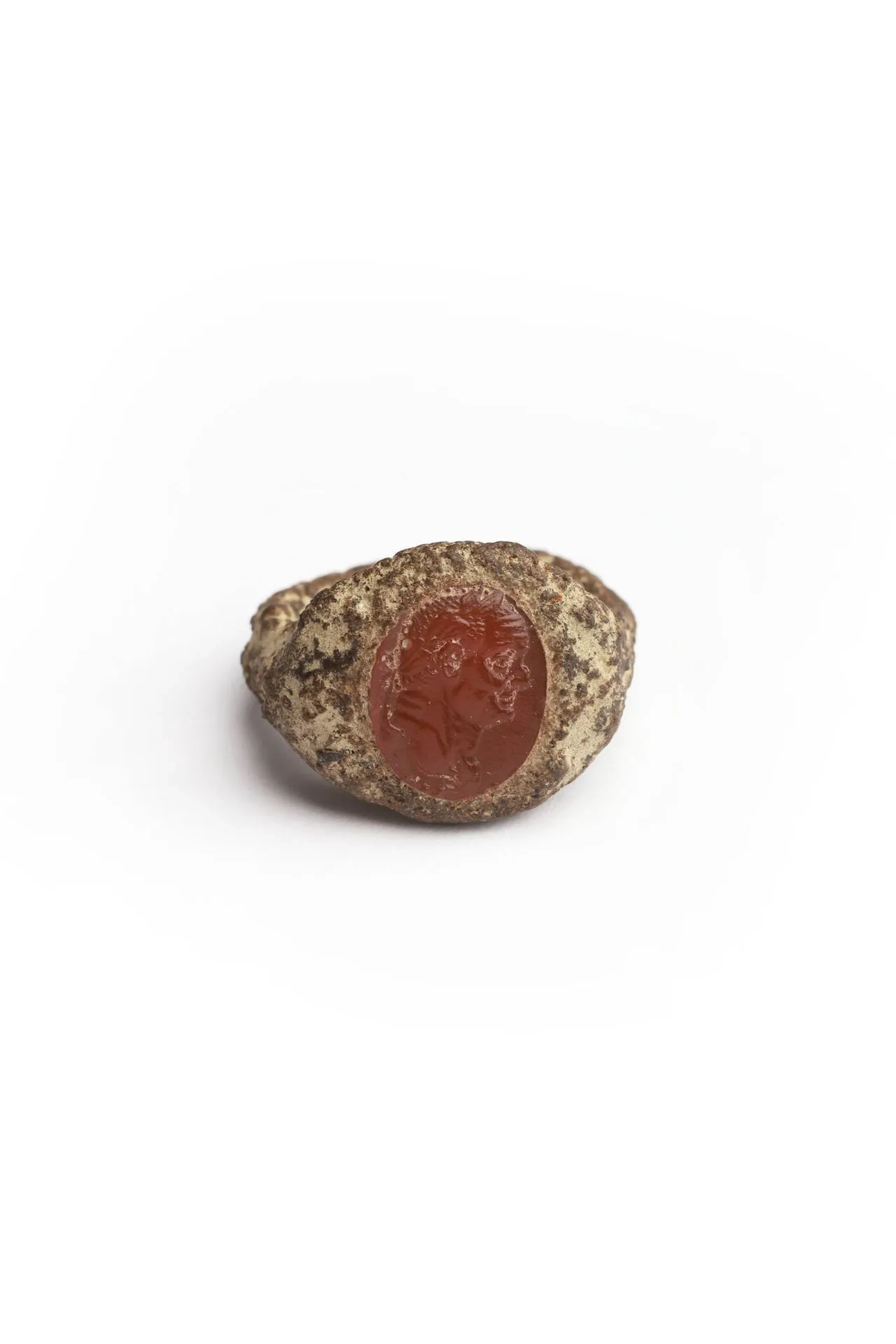 Bague en bronze à chaton ovale incrusté d’un camée ovale sur cornaline figurant un profil droit de l’empereur Vespasien lauré ou de son fils Titus. Le bronze fortement oxydé et altéré, l’intaille usée mais assez bien conservée. Époque romaine, Ier siècle ap. J.-C. TDD : 48.
